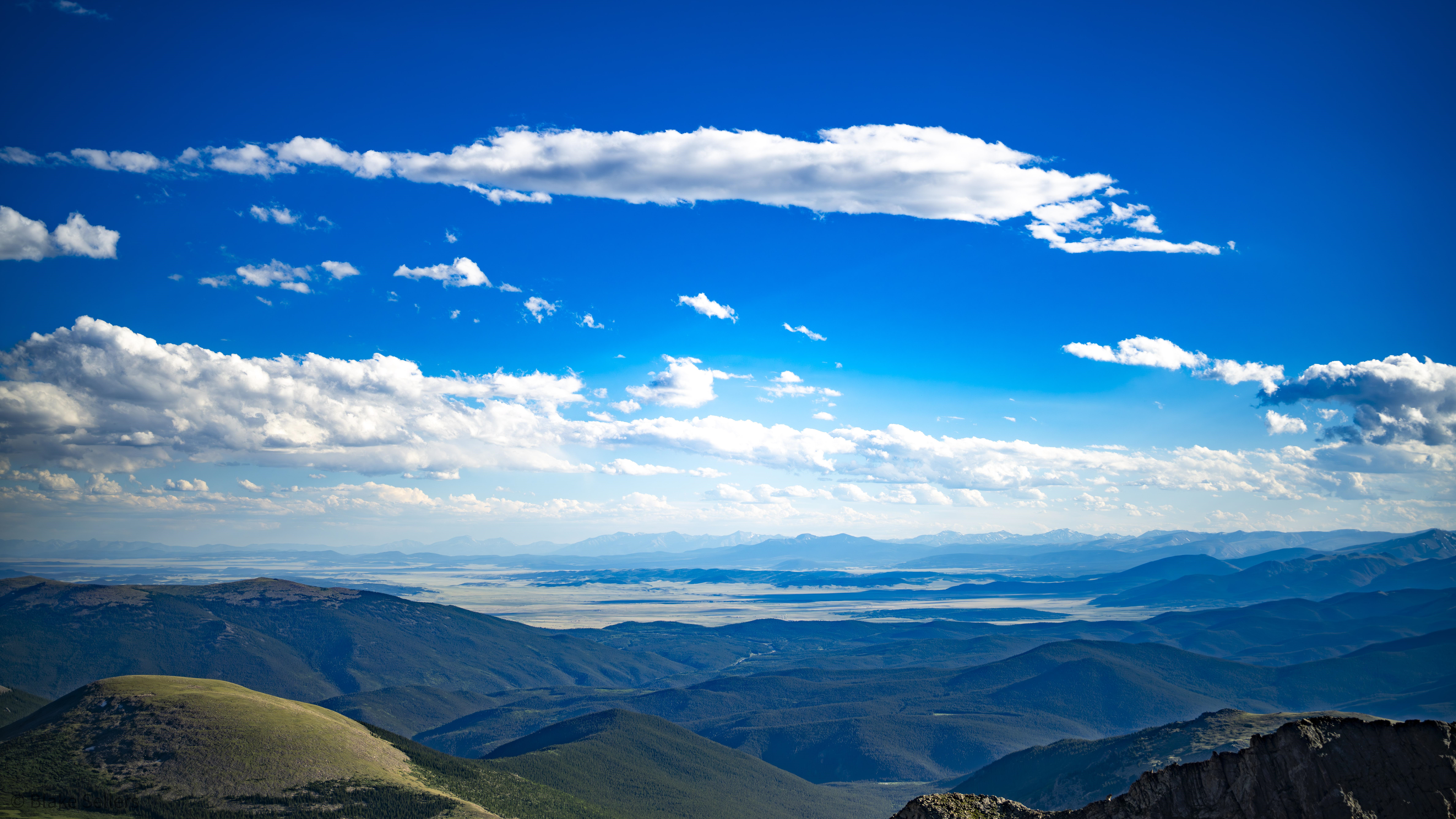 Mountains and clouds under a blue sky HD Wallpaper