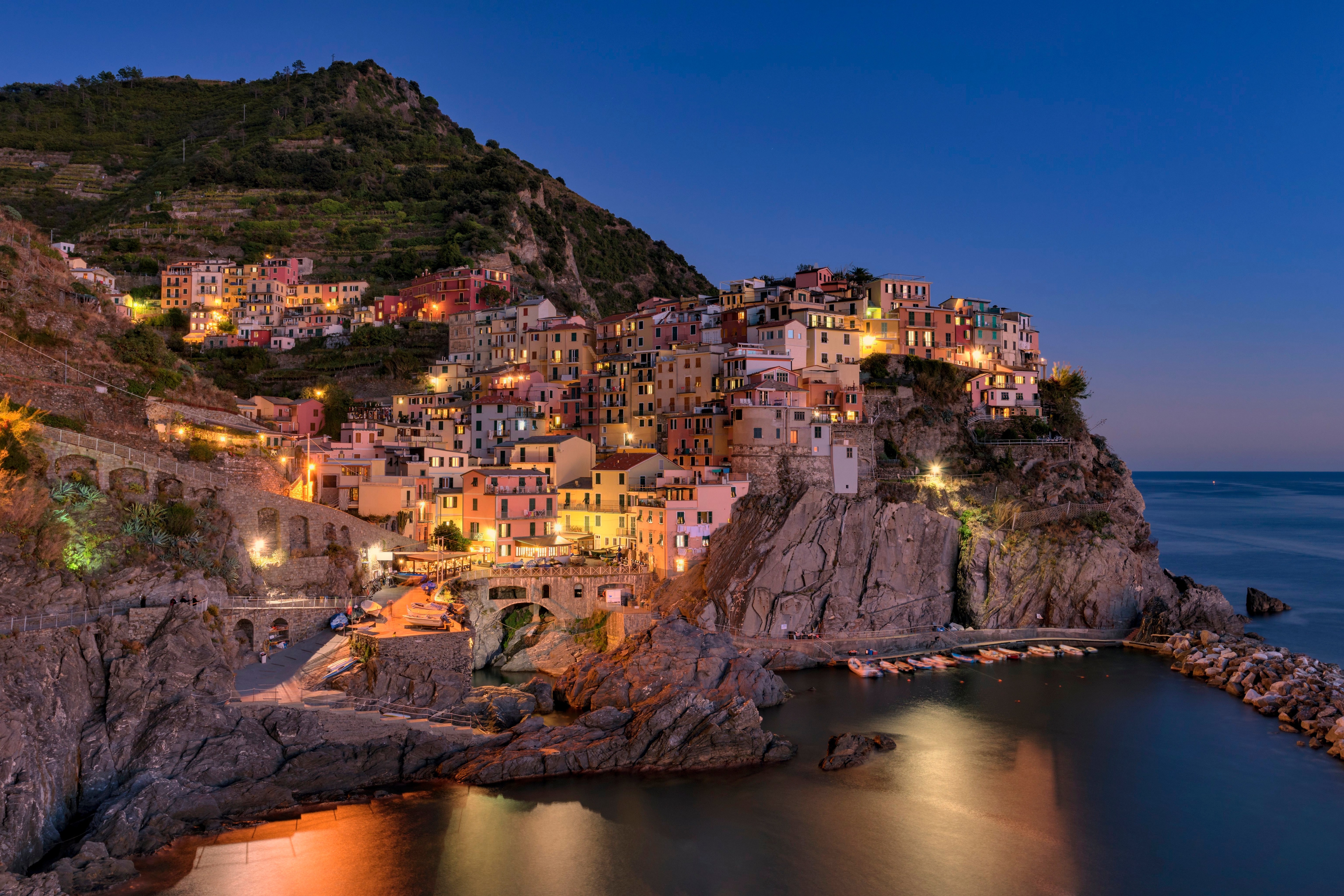 Manarola, Italy at dusk with colorful buildings on cliffs HD Wallpaper