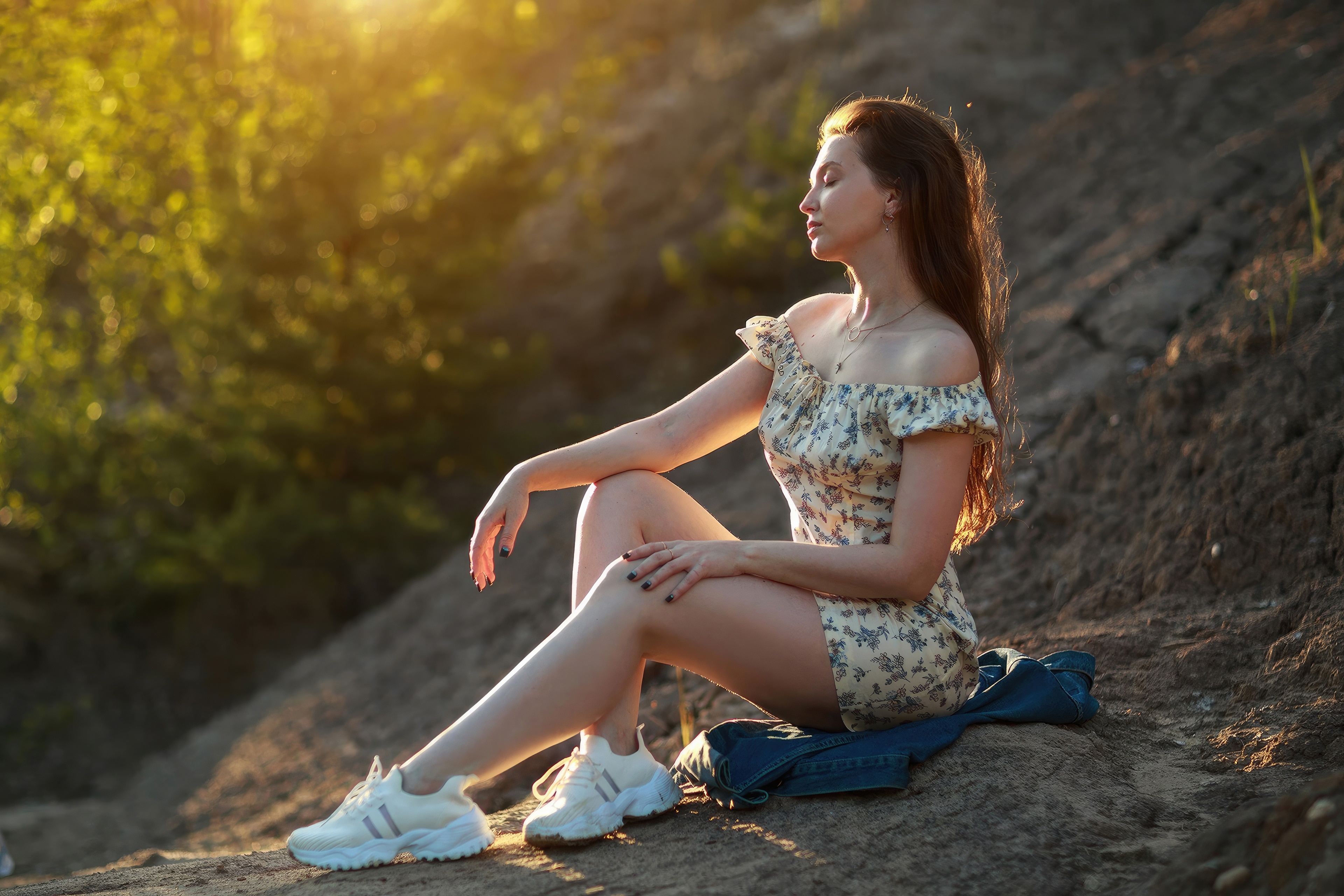 Woman in floral dress sitting outdoors in sunlight HD Wallpaper