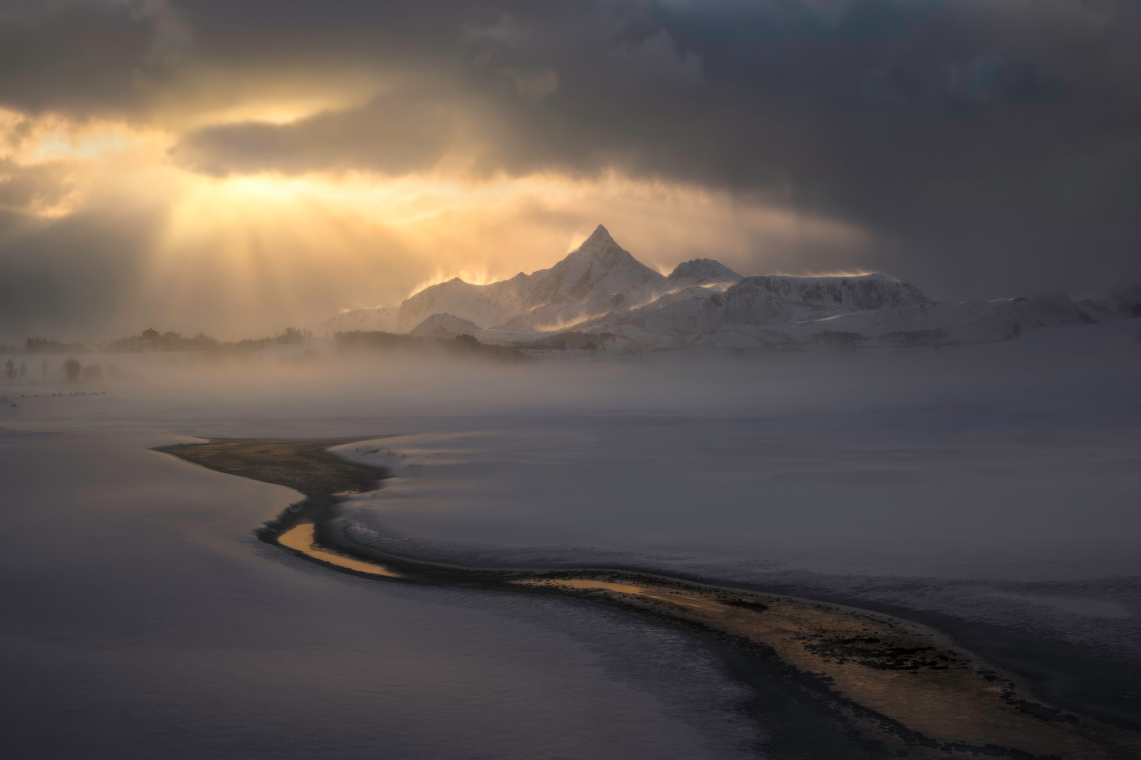 Snowy mountains with sunbeams over a misty landscape HD Wallpaper