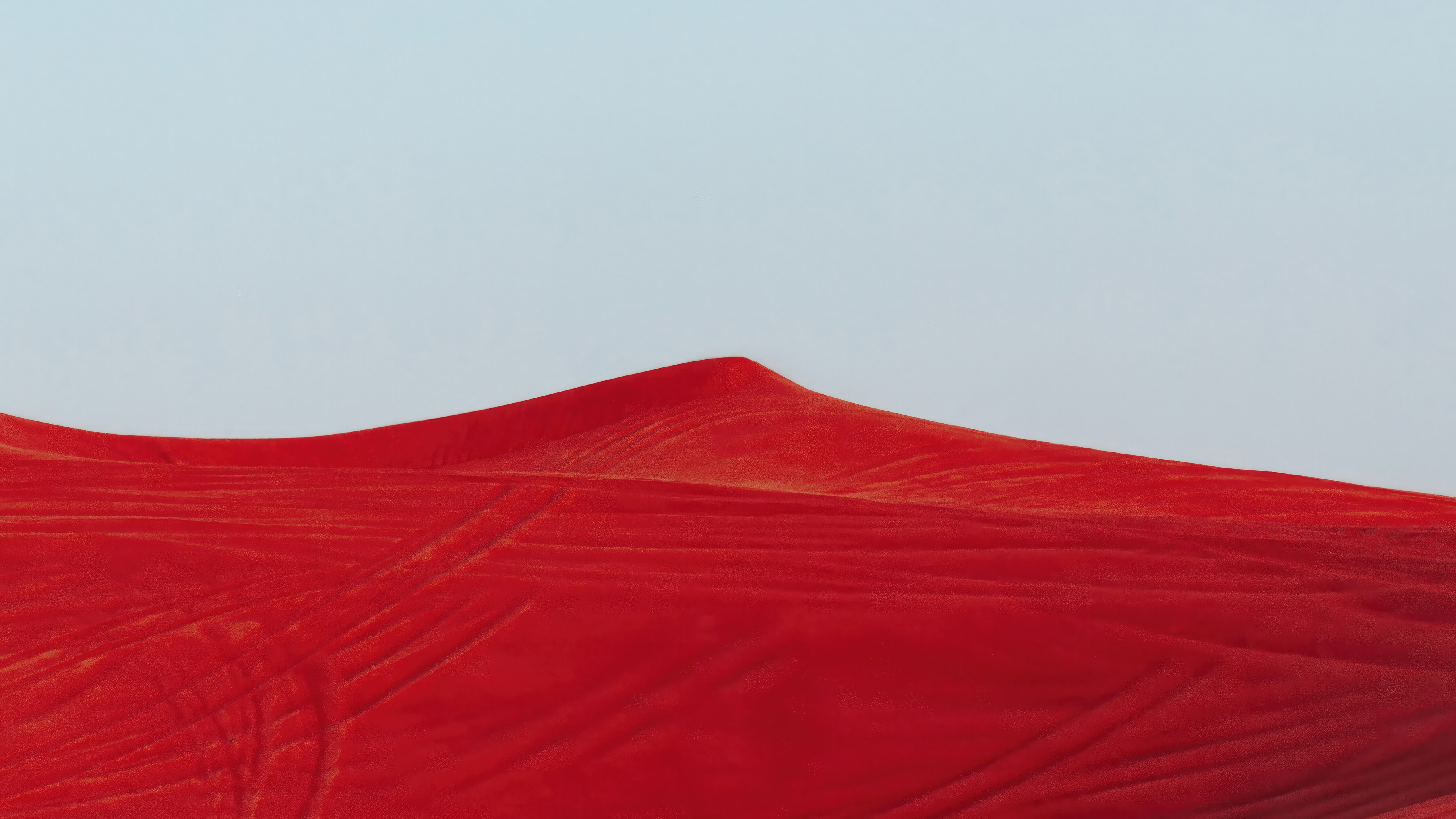Red sand dunes under a clear sky HD Wallpaper