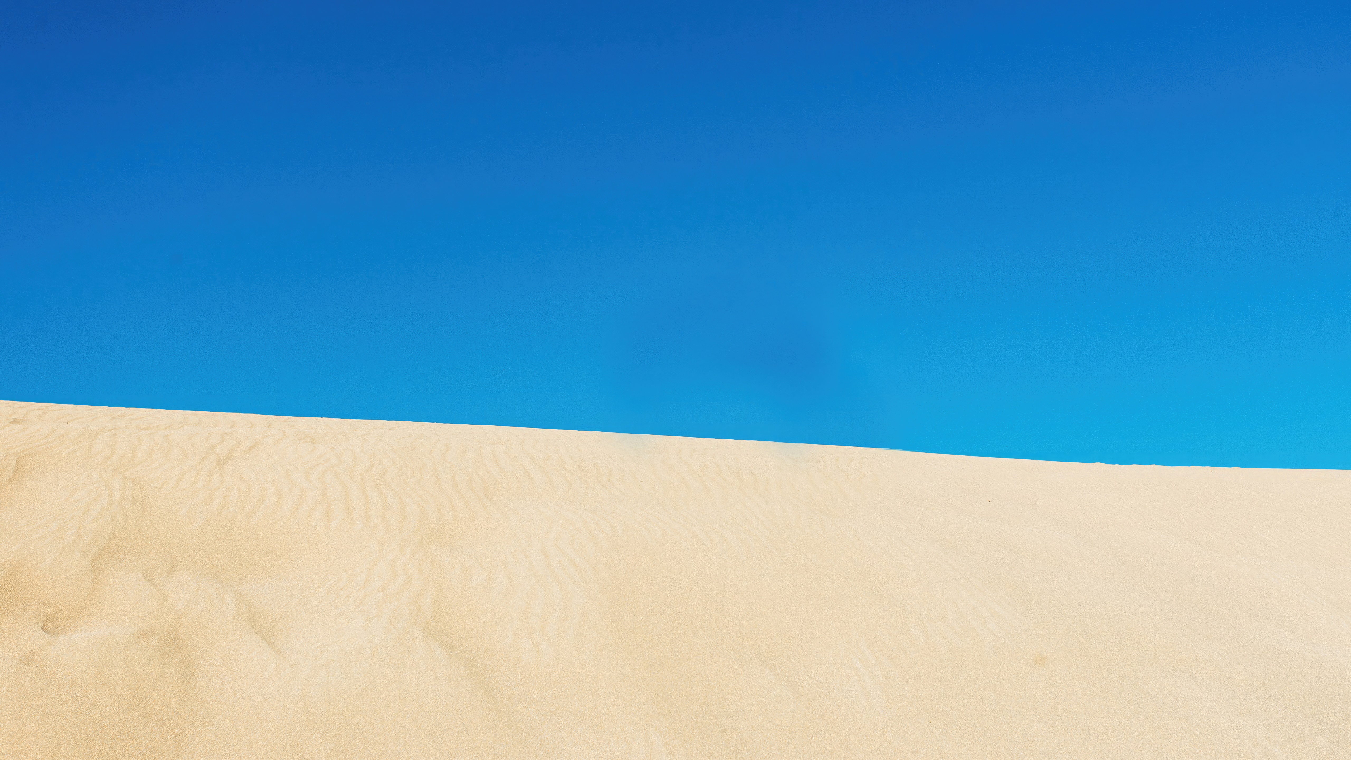 Desert sand dune under a clear blue sky HD Wallpaper