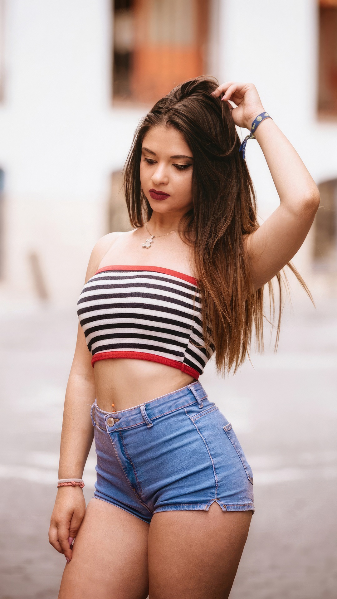 Young woman in a striped tube top and denim shorts HD Phone Wallpaper
