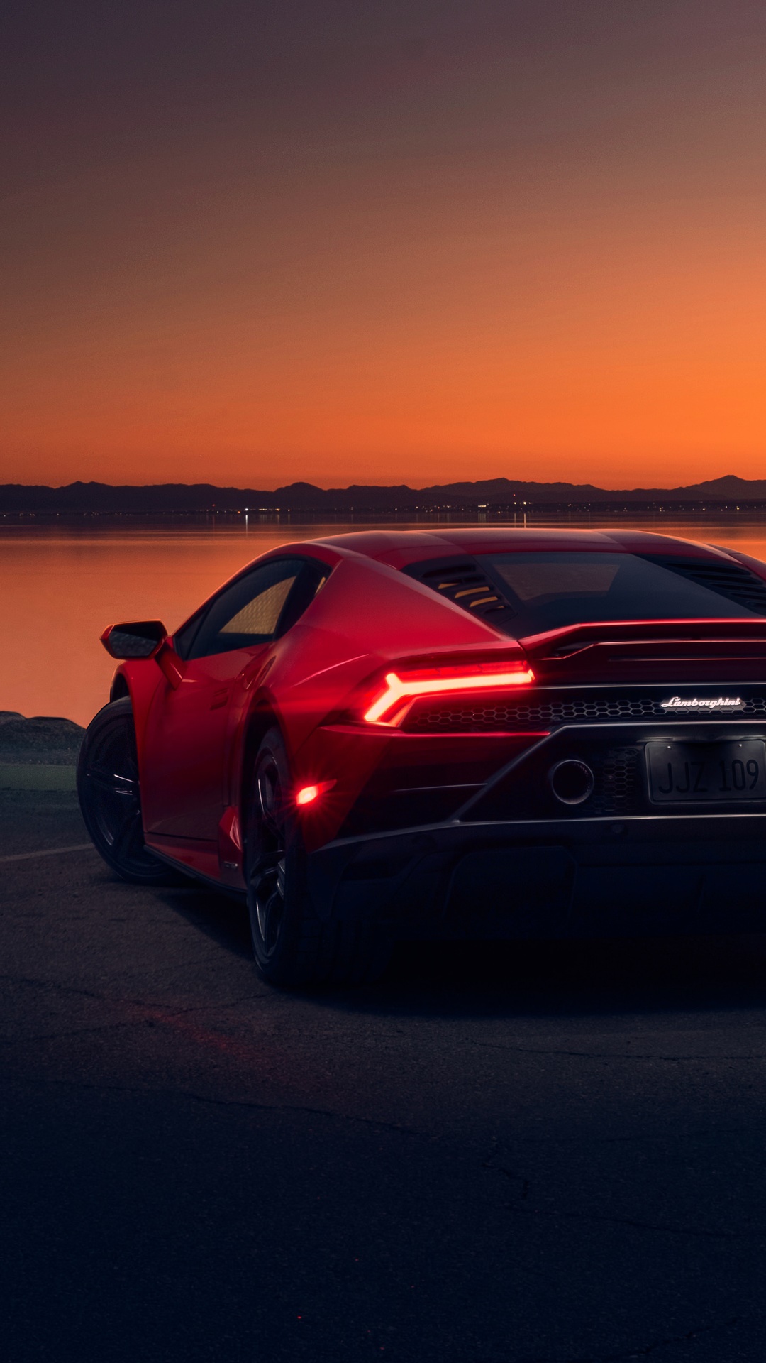 Red Lamborghini Huracan parked by a lake at sunset HD Phone Wallpaper