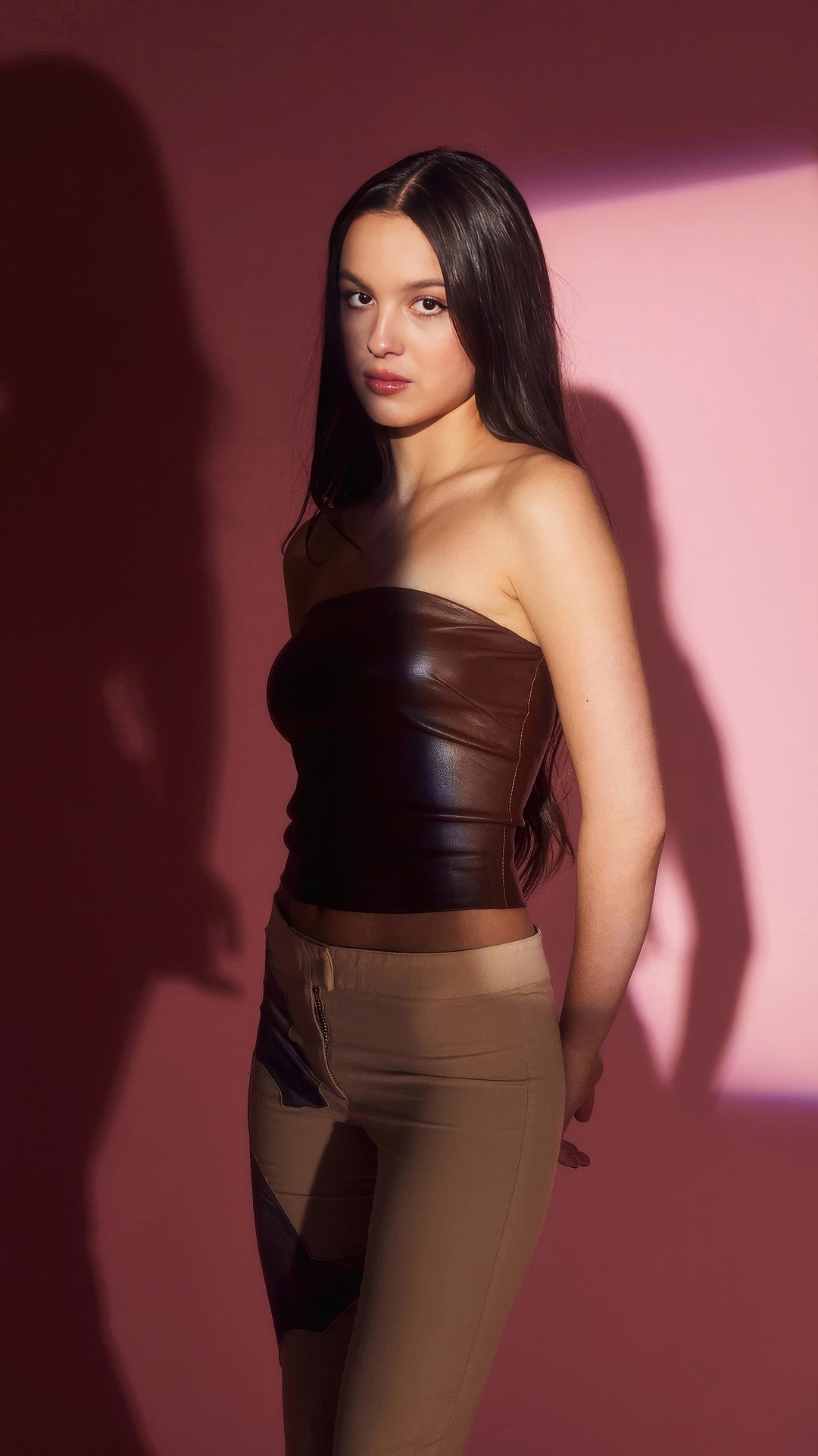 Olivia Rodrigo in a brown tube top and tan pants HD Phone Wallpaper