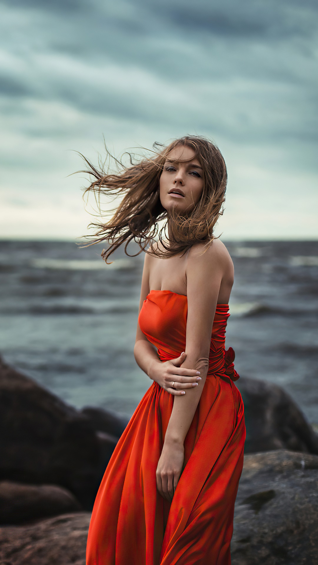 Woman in orange dress by the sea HD Phone Wallpaper