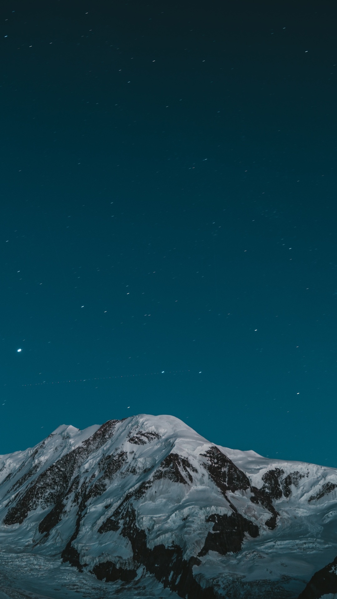 Snow-covered mountains under a starry night sky HD Phone Wallpaper