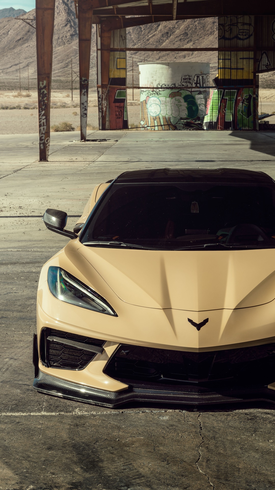 Tan Chevrolet Corvette C8 in abandoned industrial area HD Phone Wallpaper