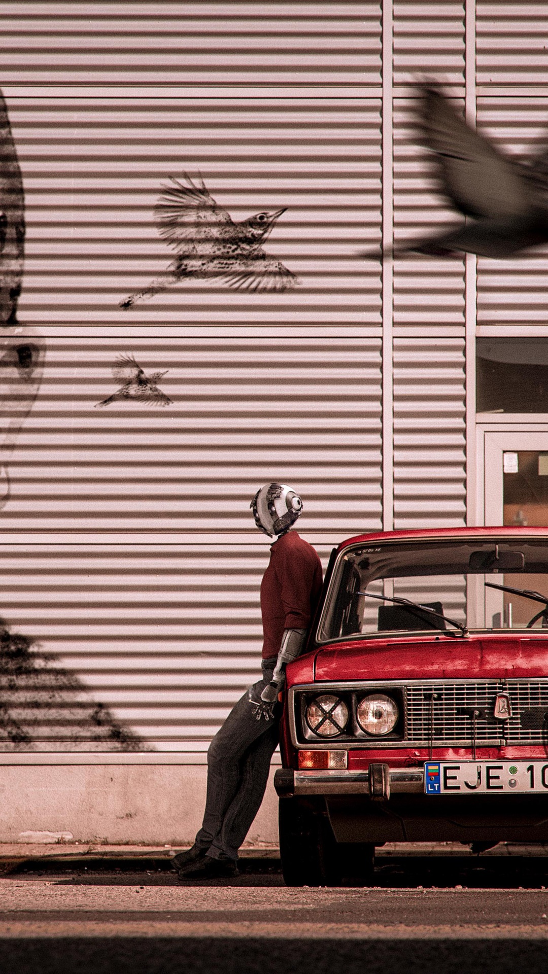 Robot leaning on a red car with birds flying HD Phone Wallpaper