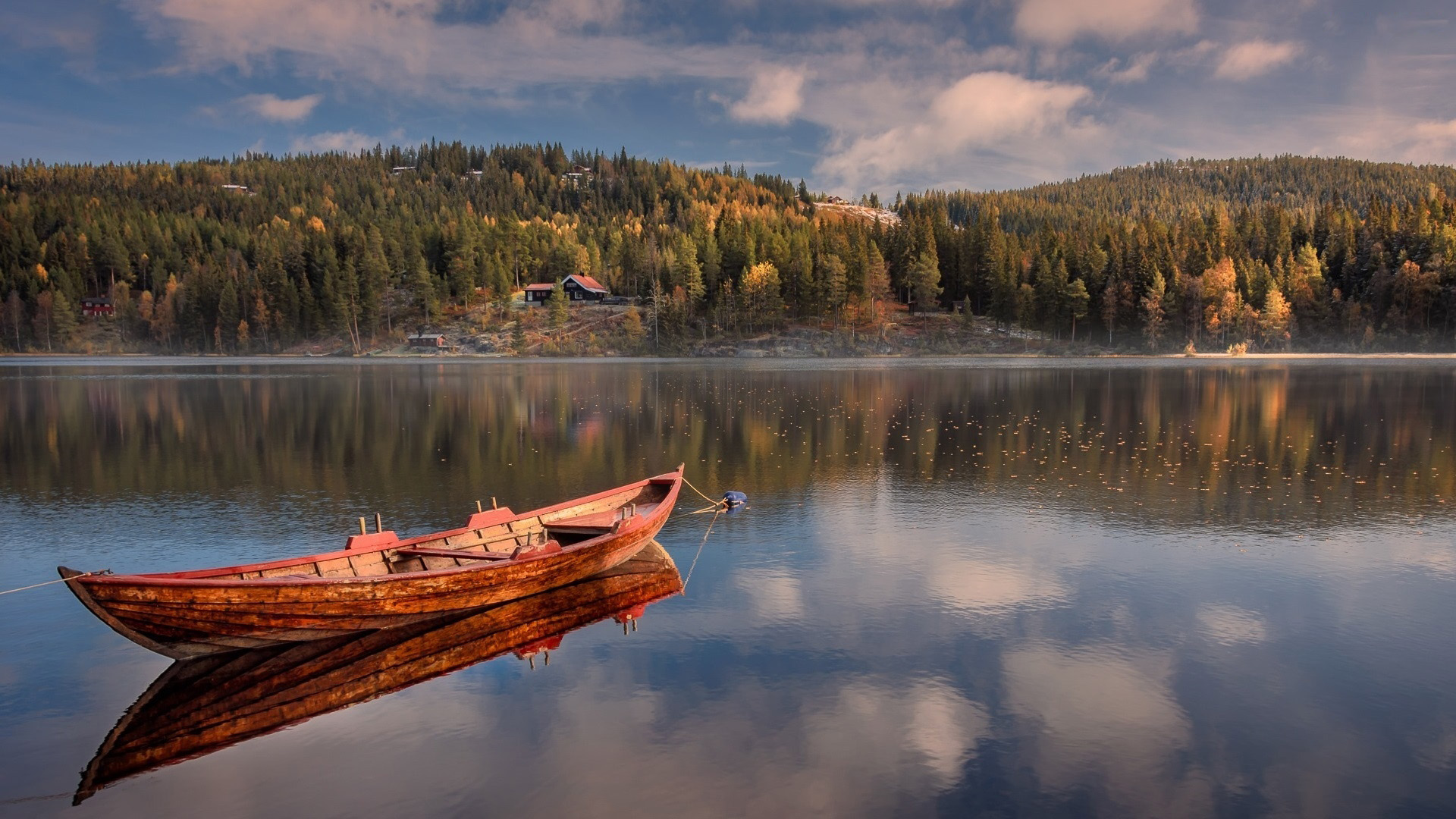 Wooden boat on a calm lake with forested hills HD Wallpaper