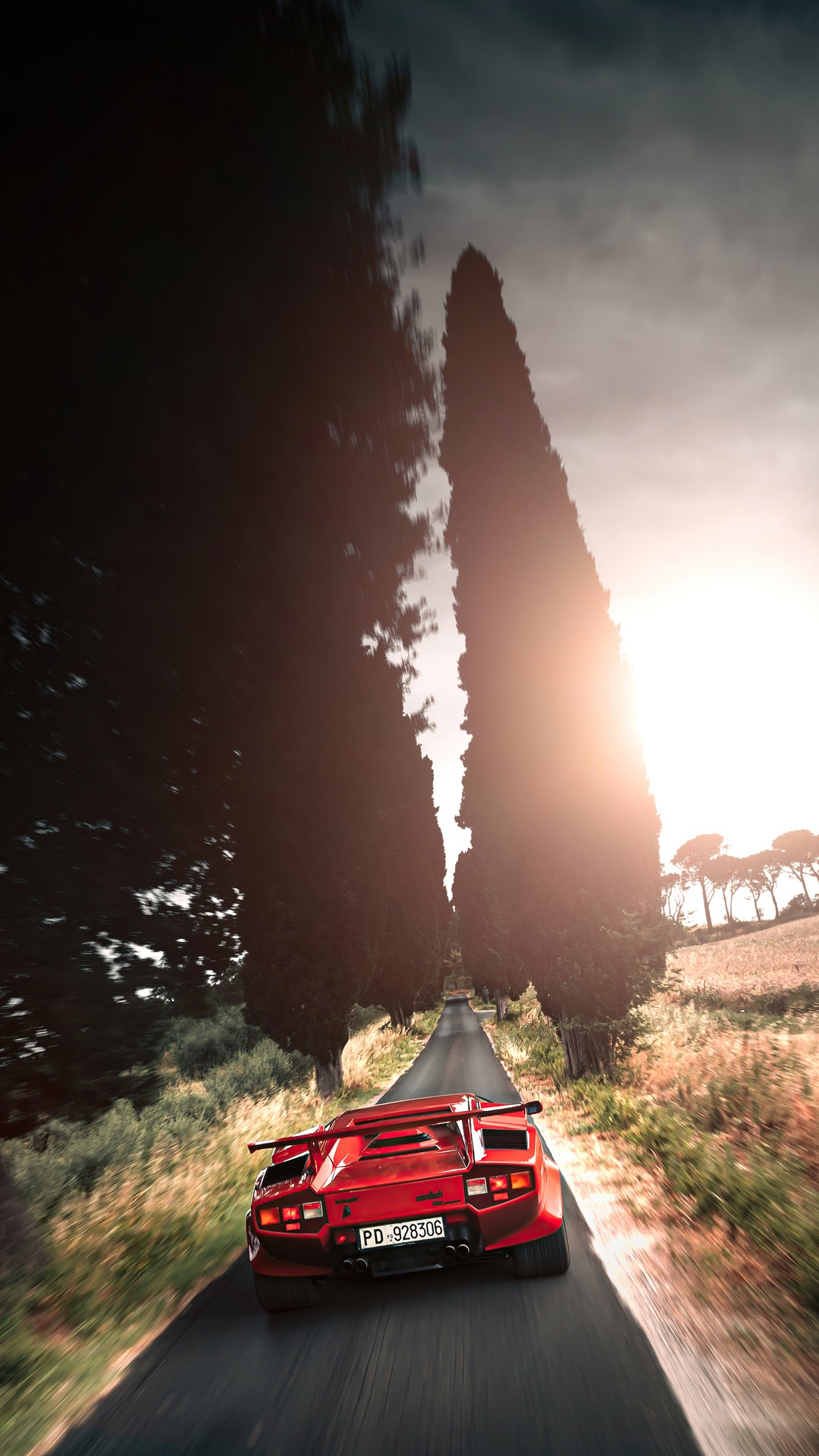 Red Lamborghini Countach driving on a road HD Phone Wallpaper