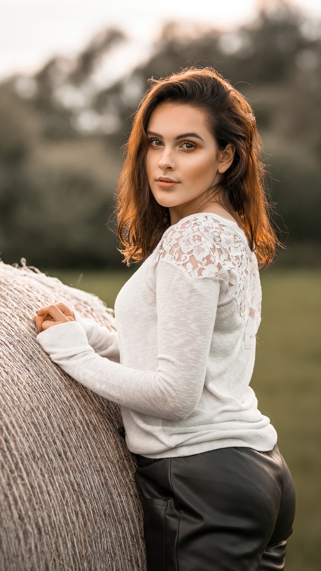 Model posing near a hay bale HD Phone Wallpaper