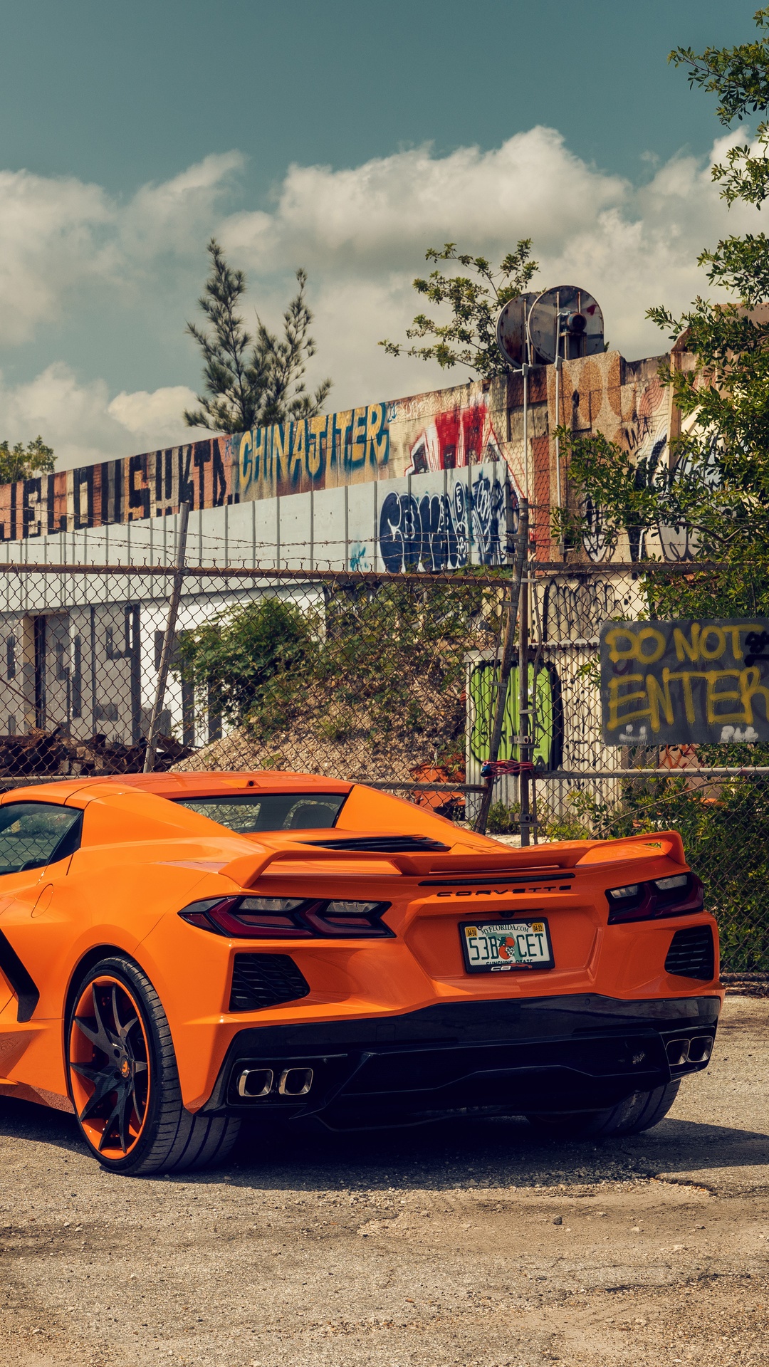 Orange Chevrolet Corvette parked near graffiti wall HD Phone Wallpaper