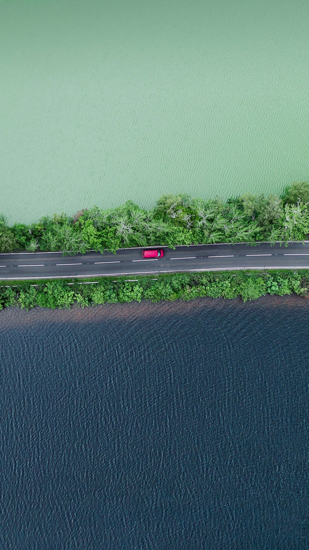 Aerial view of a red car on a road between two bodies of water HD Phone Wallpaper