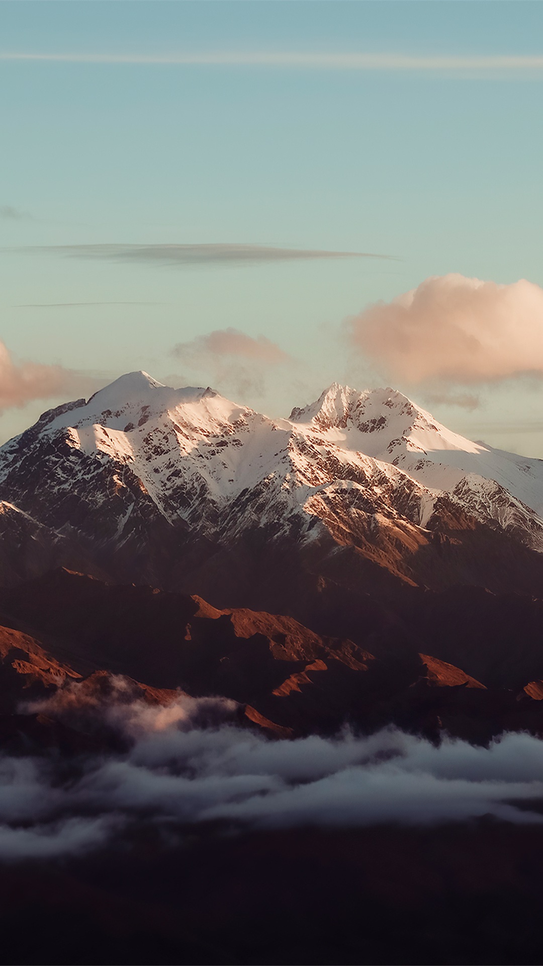 Snow-capped mountains emerge from clouds at sunset HD Phone Wallpaper
