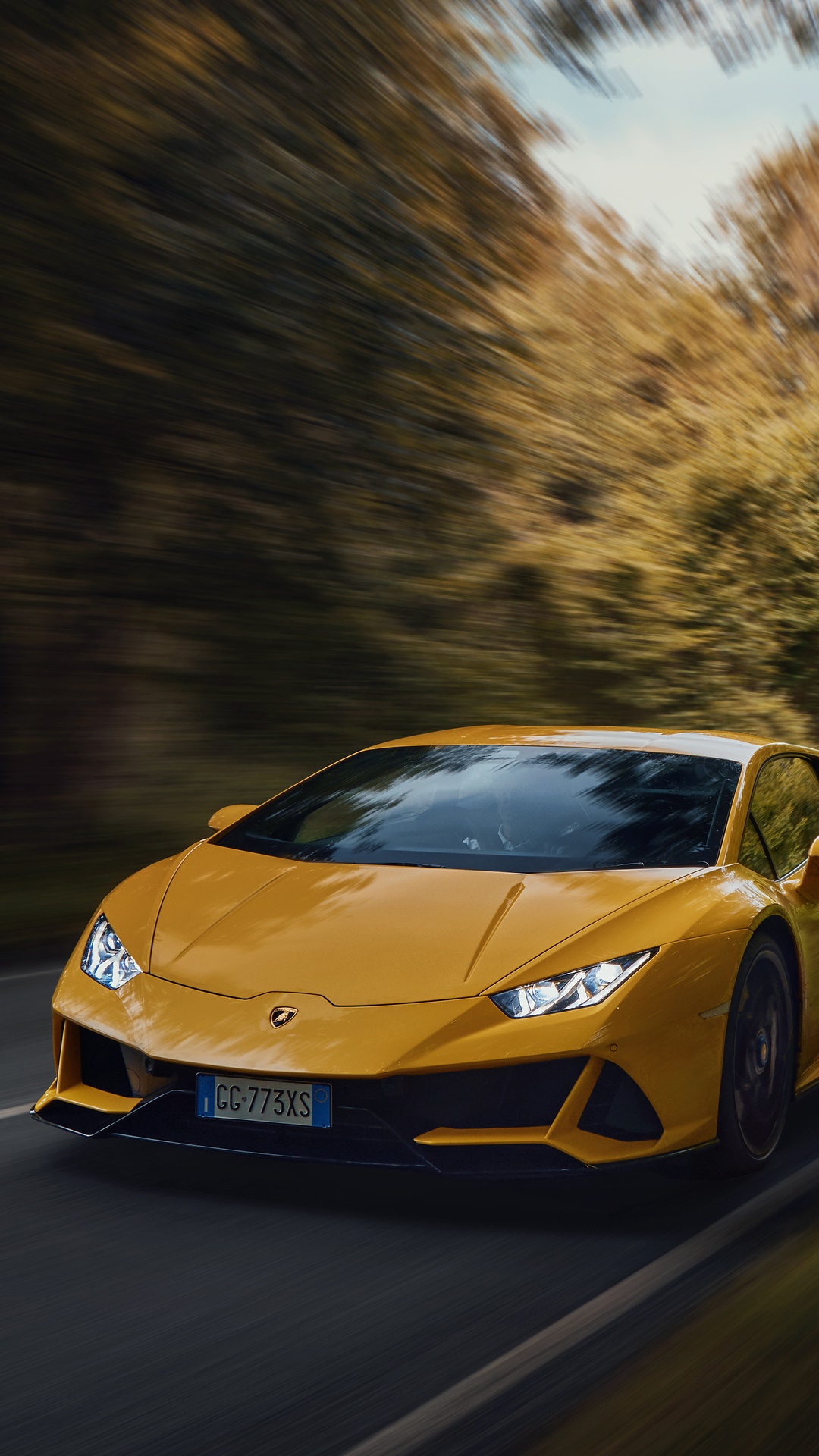 Yellow Lamborghini Huracan Evo driving on a road HD Phone Wallpaper