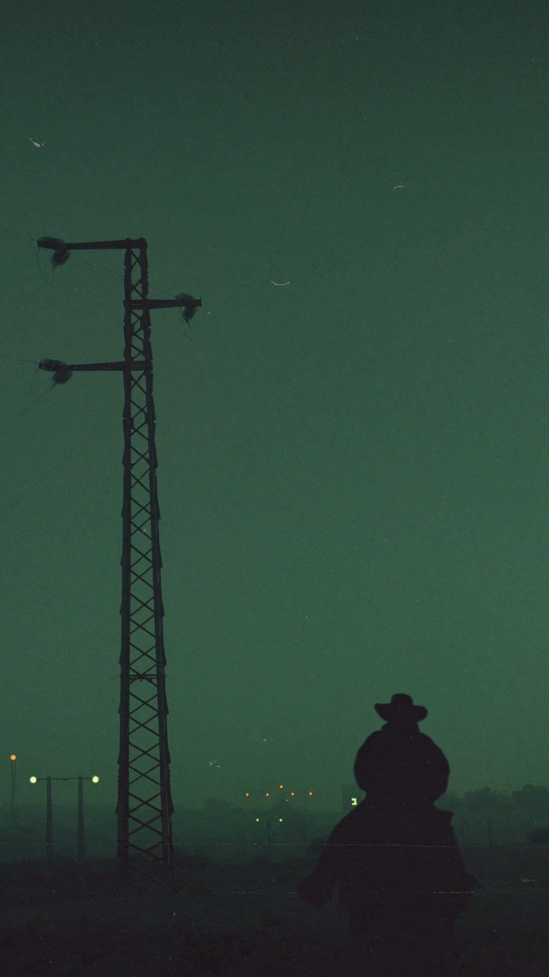 Silhouette of a figure with a cowboy hat against a dark sky HD Phone Wallpaper