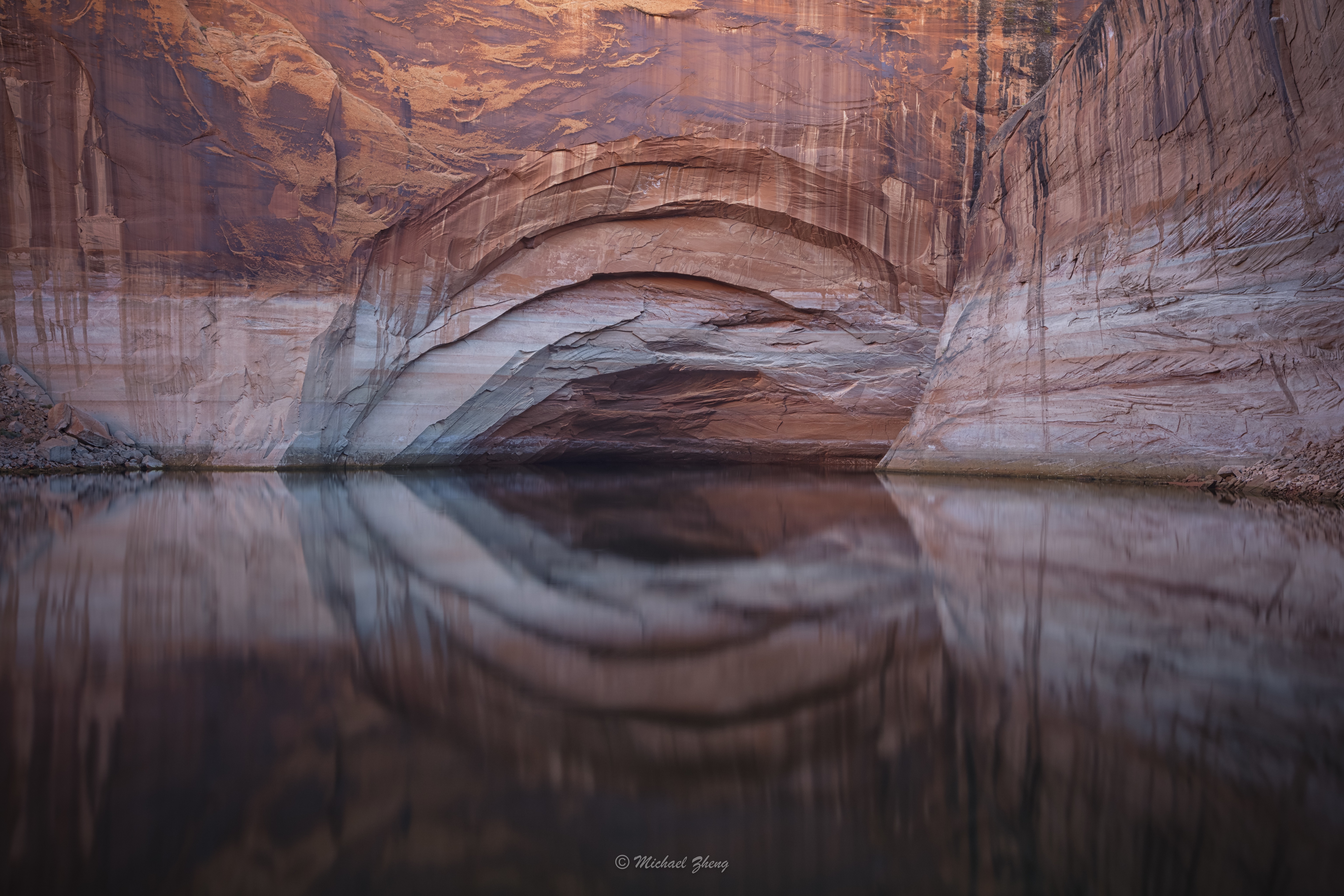 4K cliff face reflected in calm water HD Wallpaper