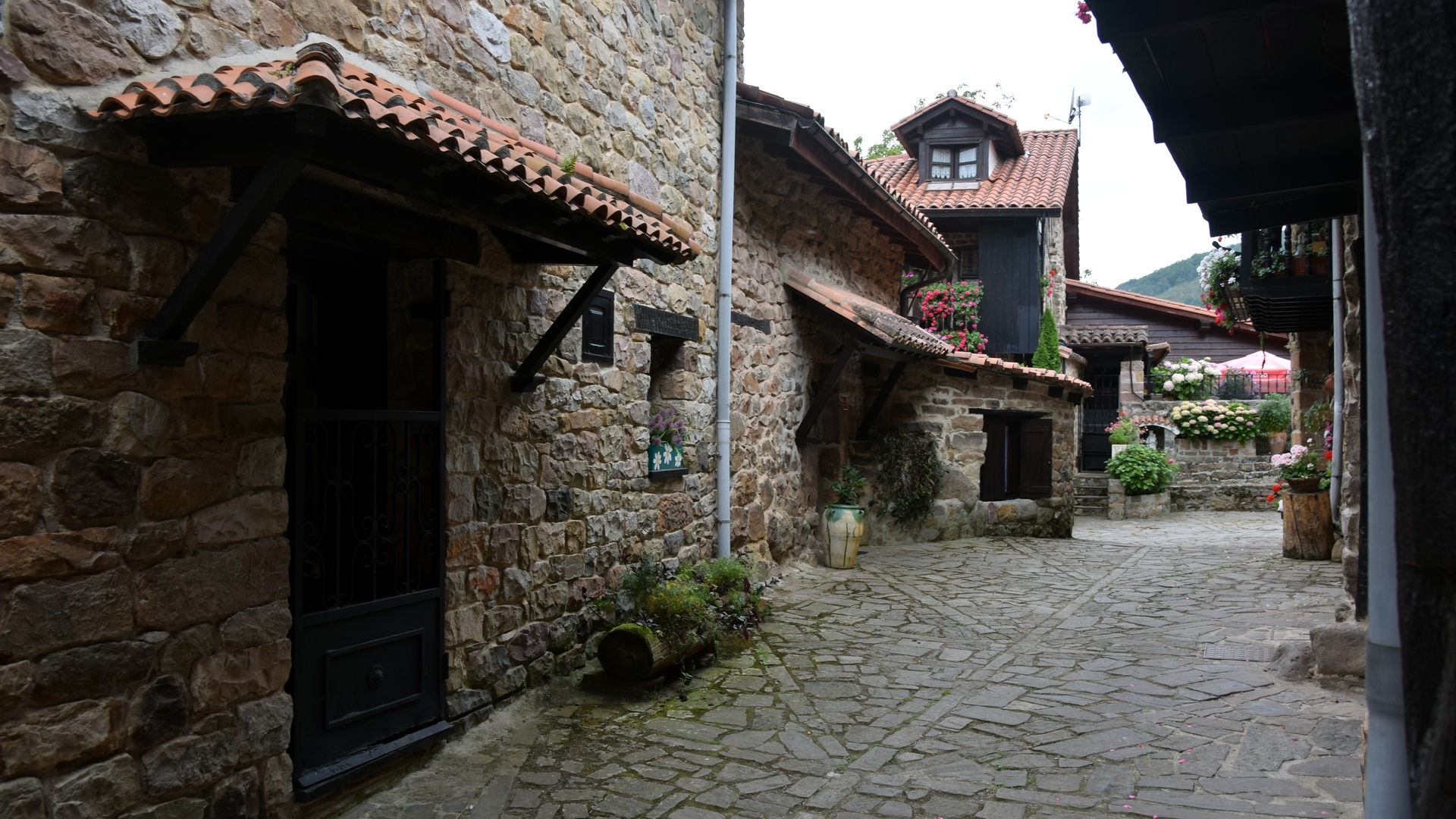 Stone buildings and cobblestone street in Barcena Mayor, Spain HD Wallpaper