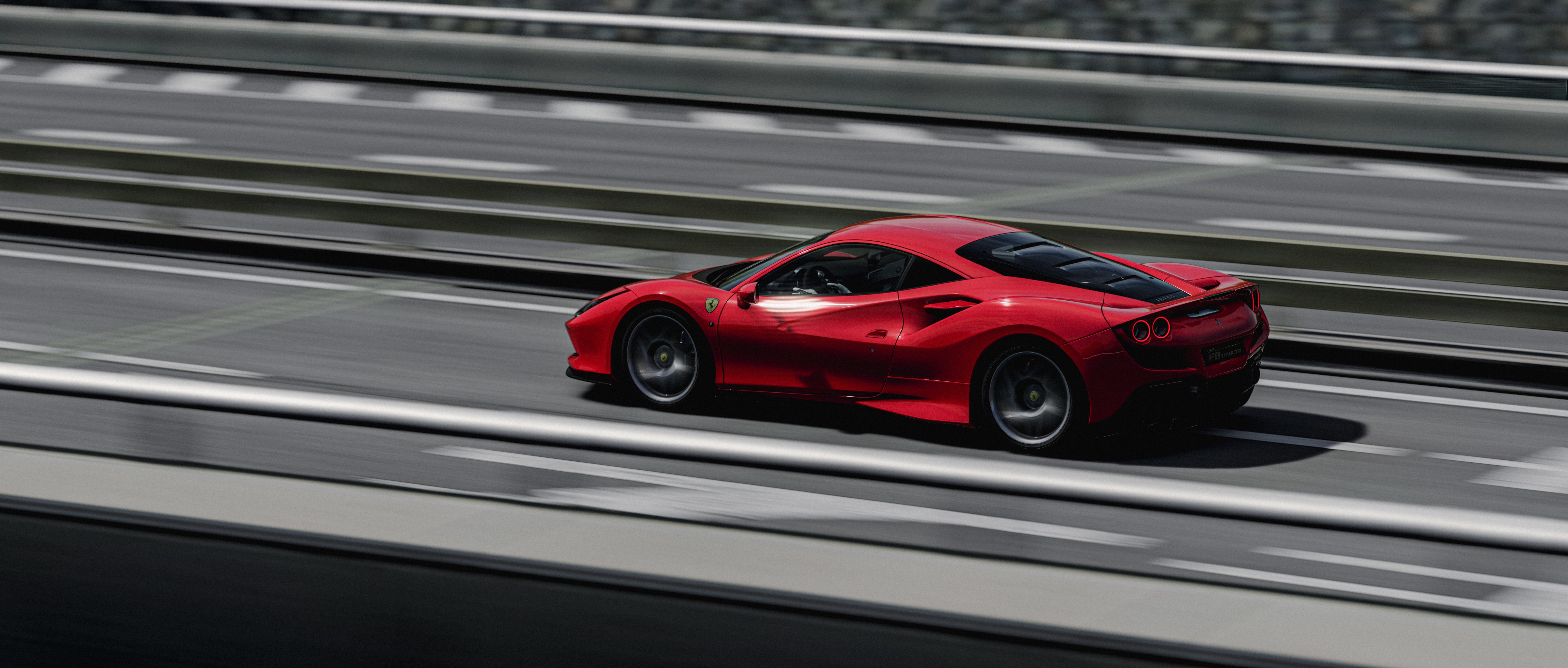 Ferrari F8 Tributo driving on a road HD Wallpaper