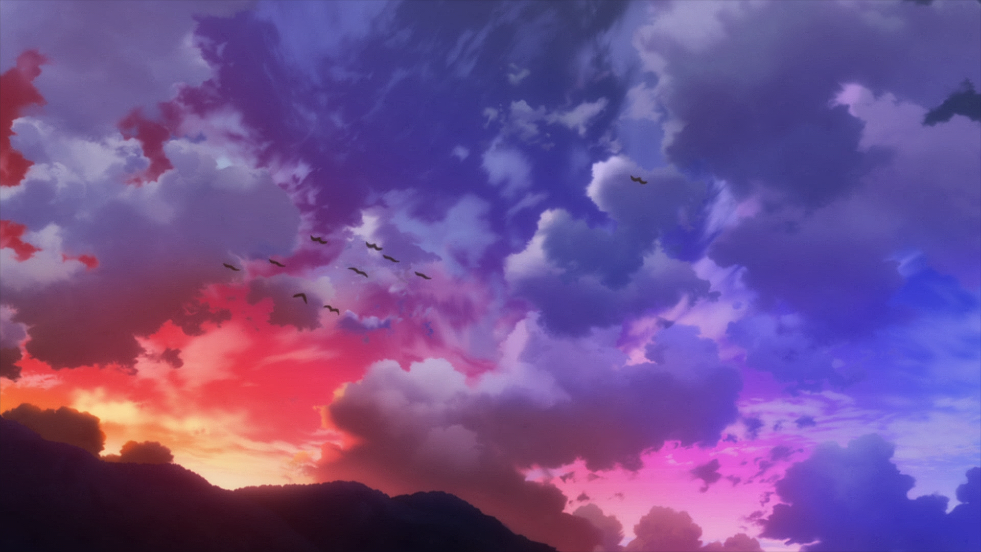 Birds flying in a colorful sunset sky over mountains HD Wallpaper