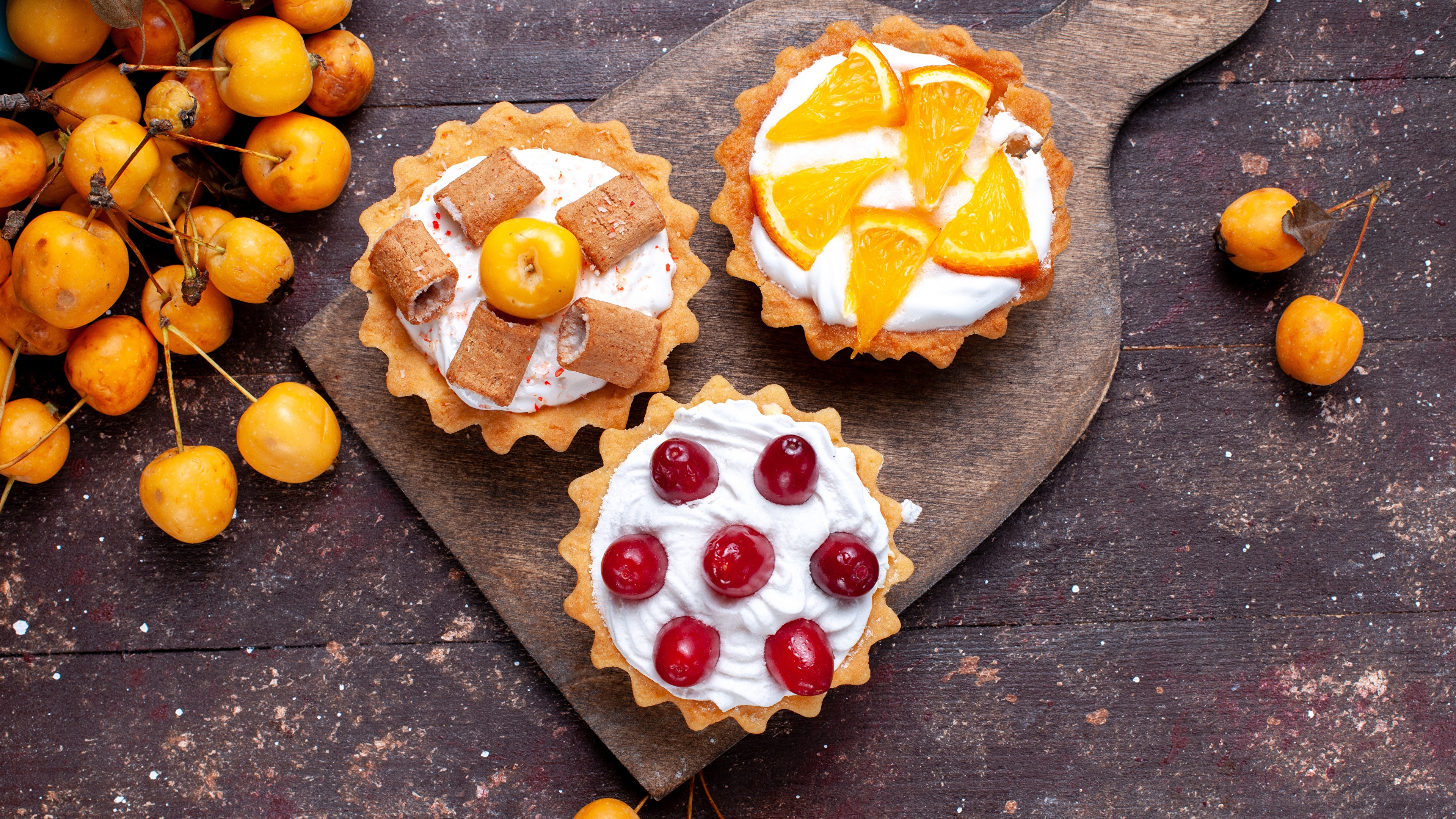 Dessert tarts with fruit and cream on a wooden board HD Wallpaper