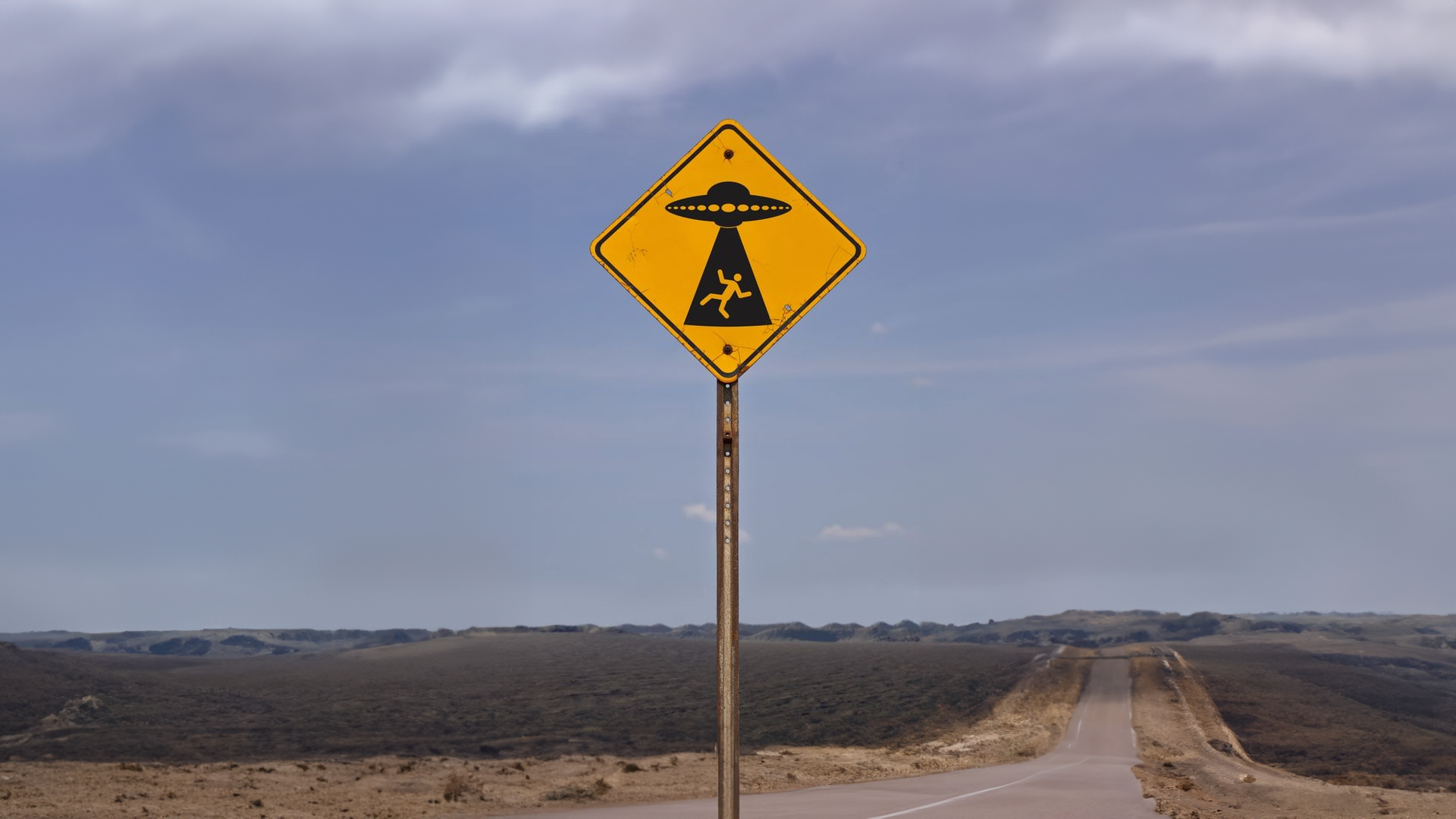Yellow diamond sign with alien abduction symbol on a road HD Wallpaper