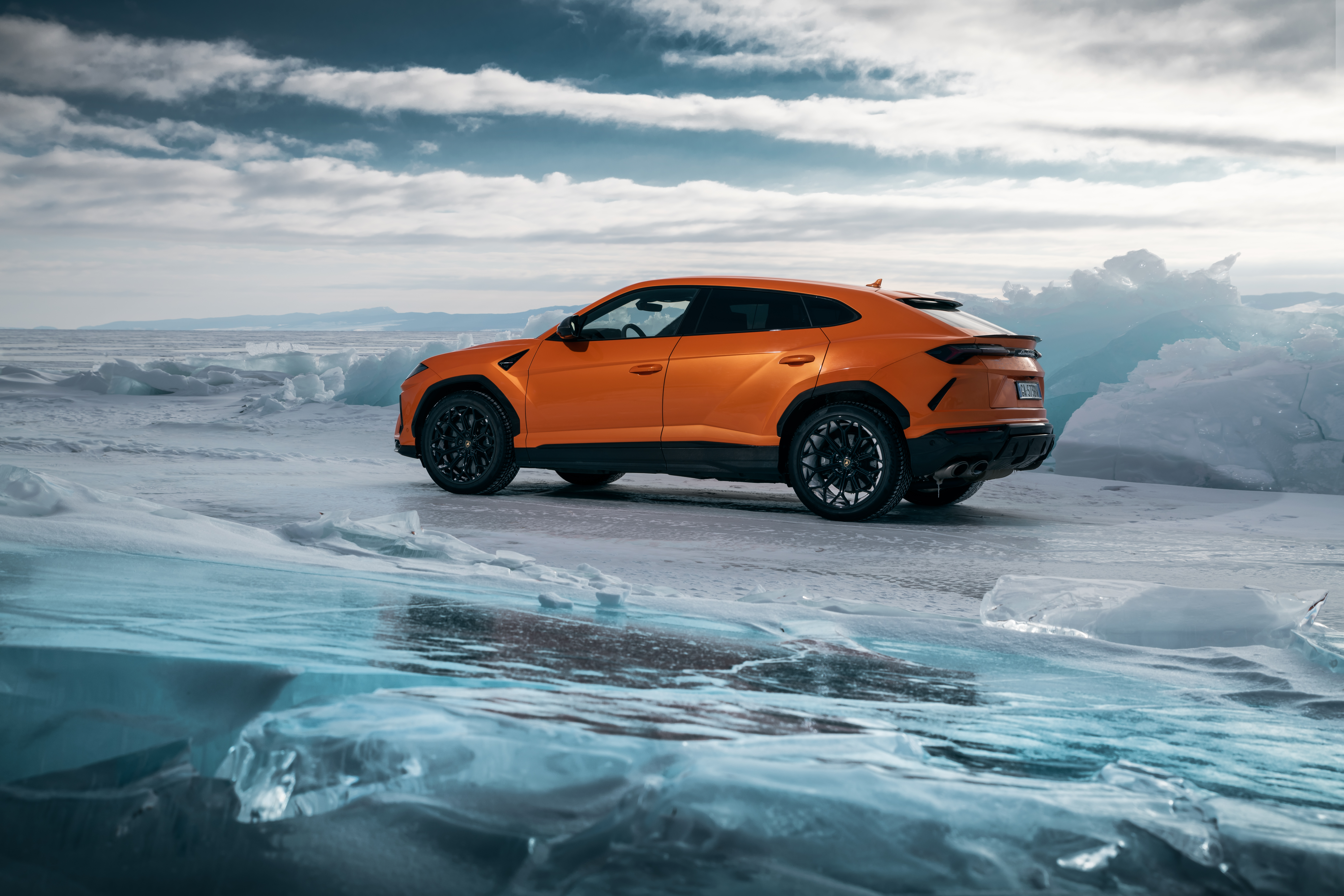 Orange Lamborghini Urus on a frozen landscape HD Wallpaper