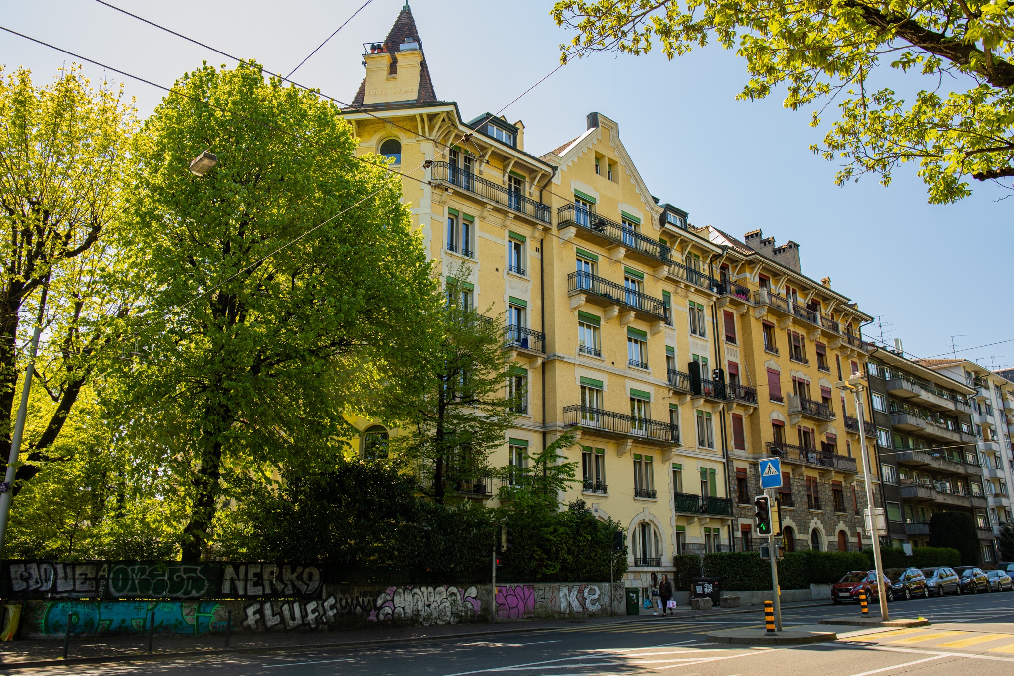 Yellow apartment buildings with trees and graffiti HD Wallpaper