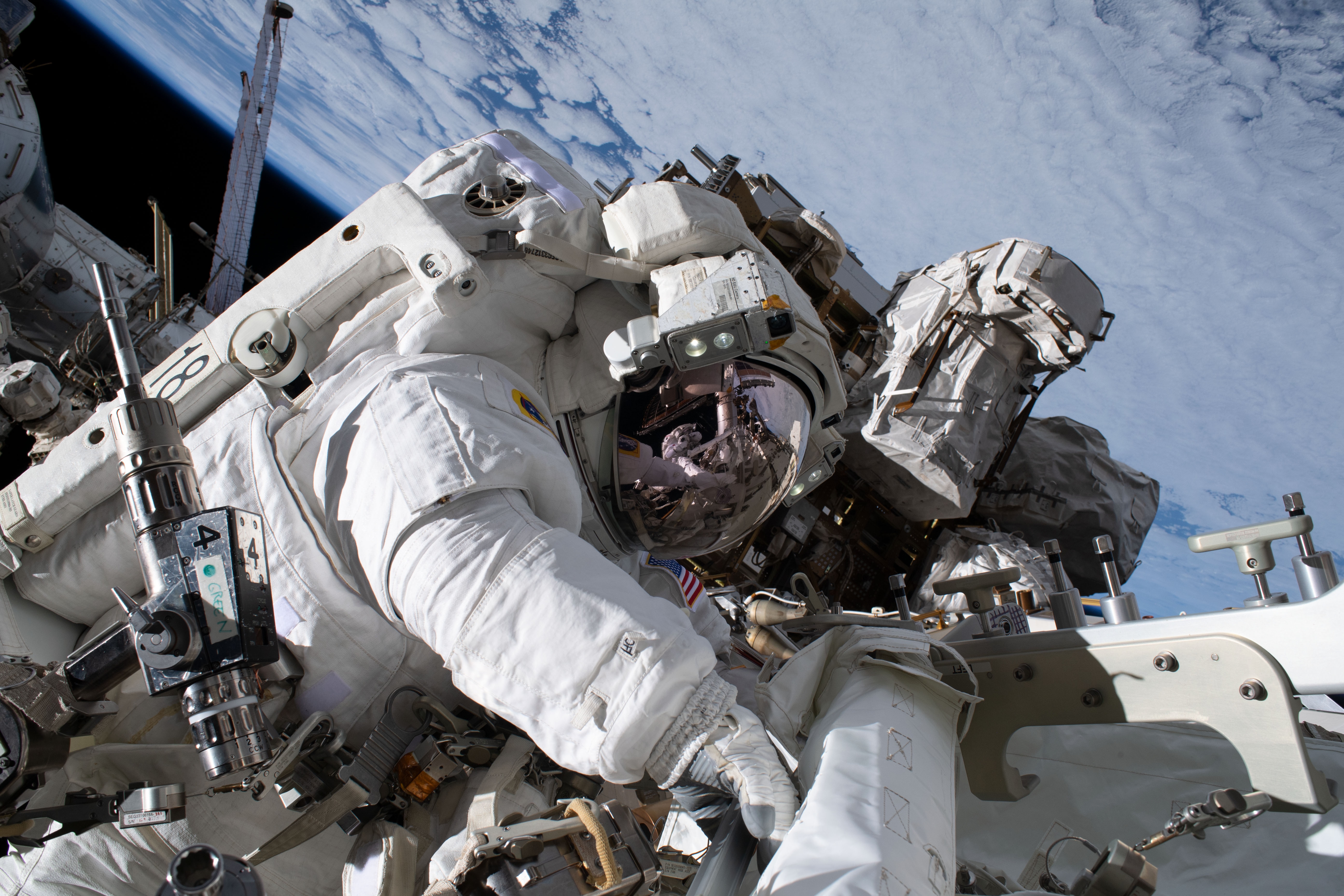 Astronaut in spacesuit performing spacewalk with Earth in background HD Wallpaper