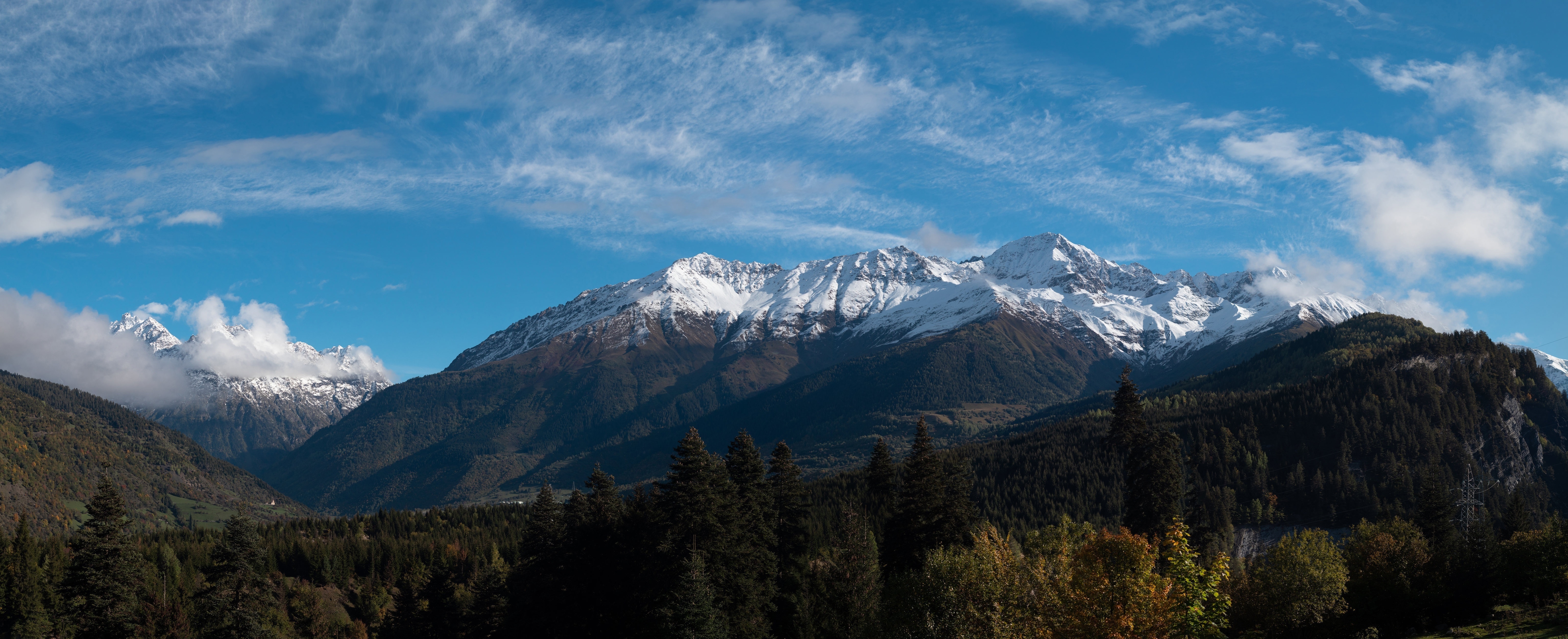 Snowy mountain peaks under a blue sky with clouds HD Wallpaper