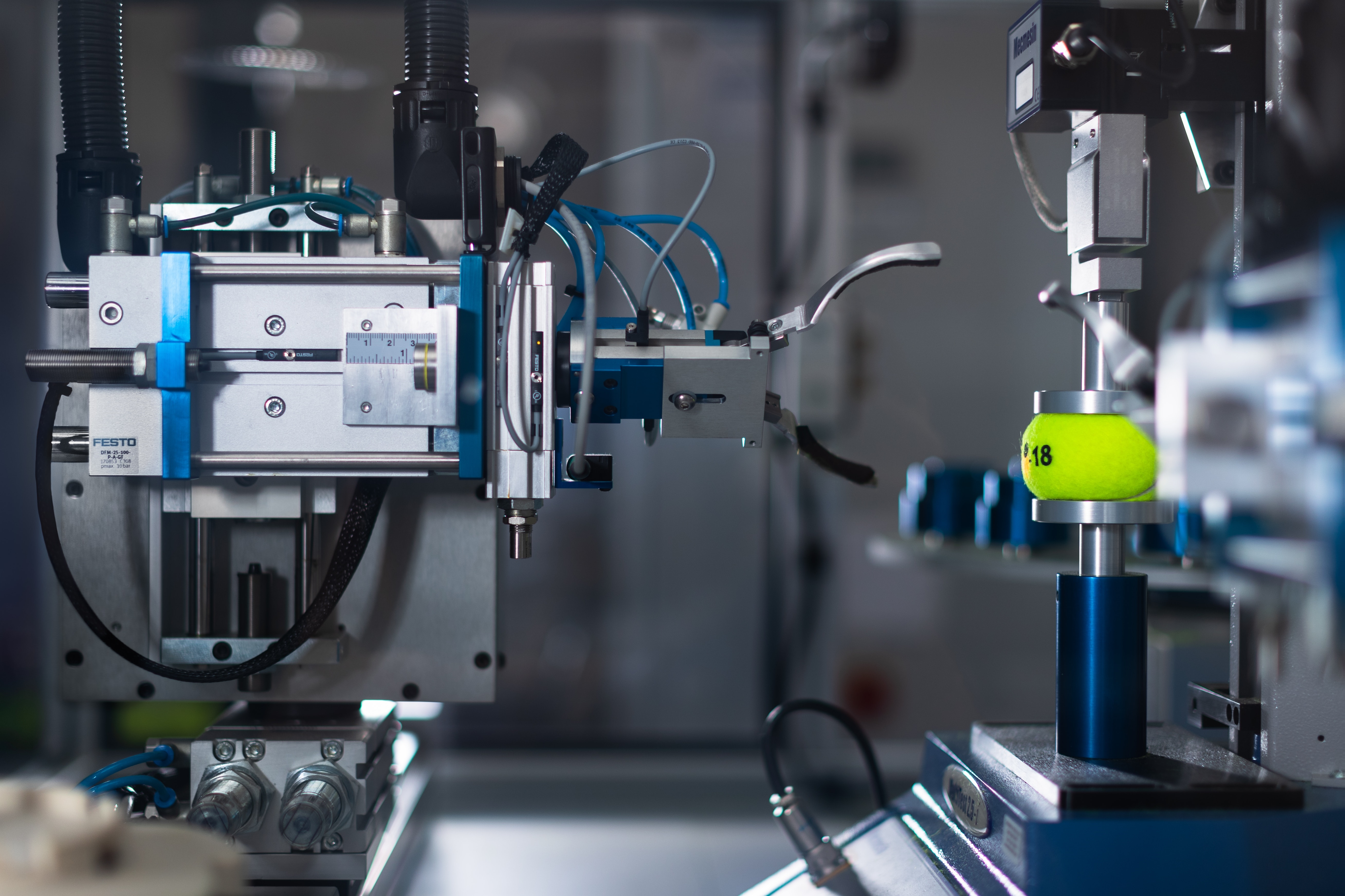 Automated machine testing a tennis ball HD Wallpaper