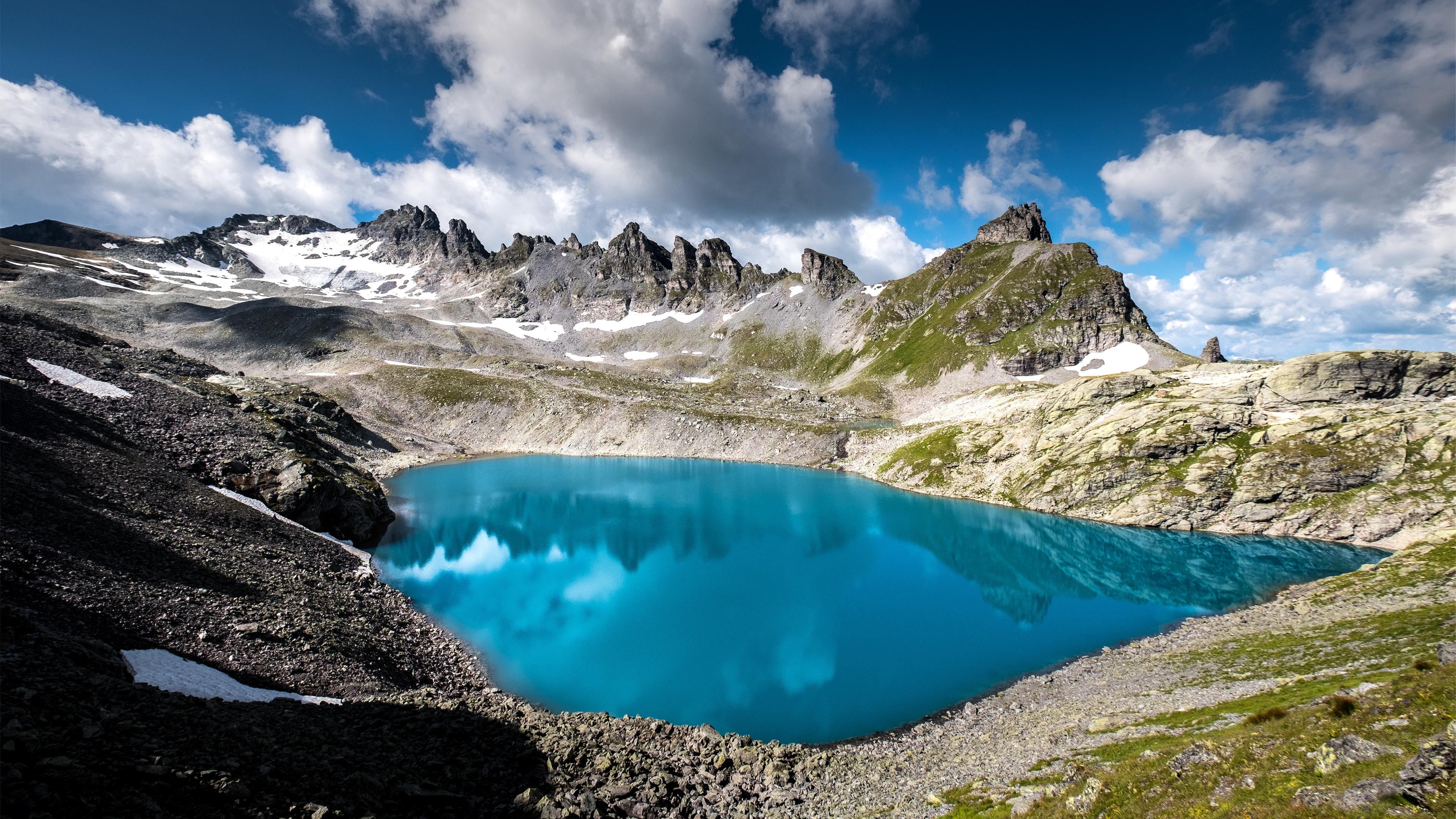 Turquoise lake reflecting mountains in the Swiss Alps HD Wallpaper