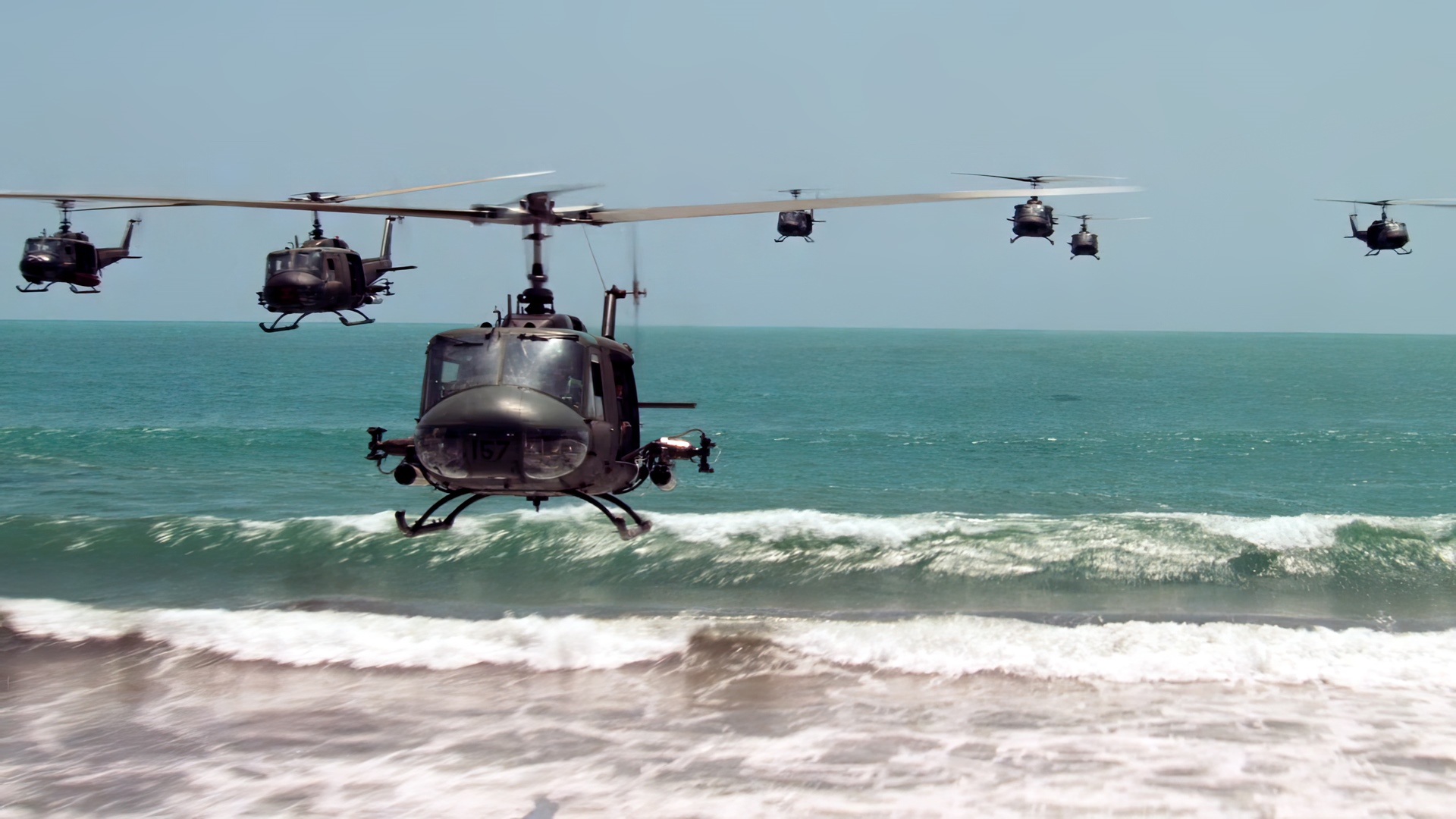 Bell UH-1 Iroquois helicopters flying over the sea HD Wallpaper