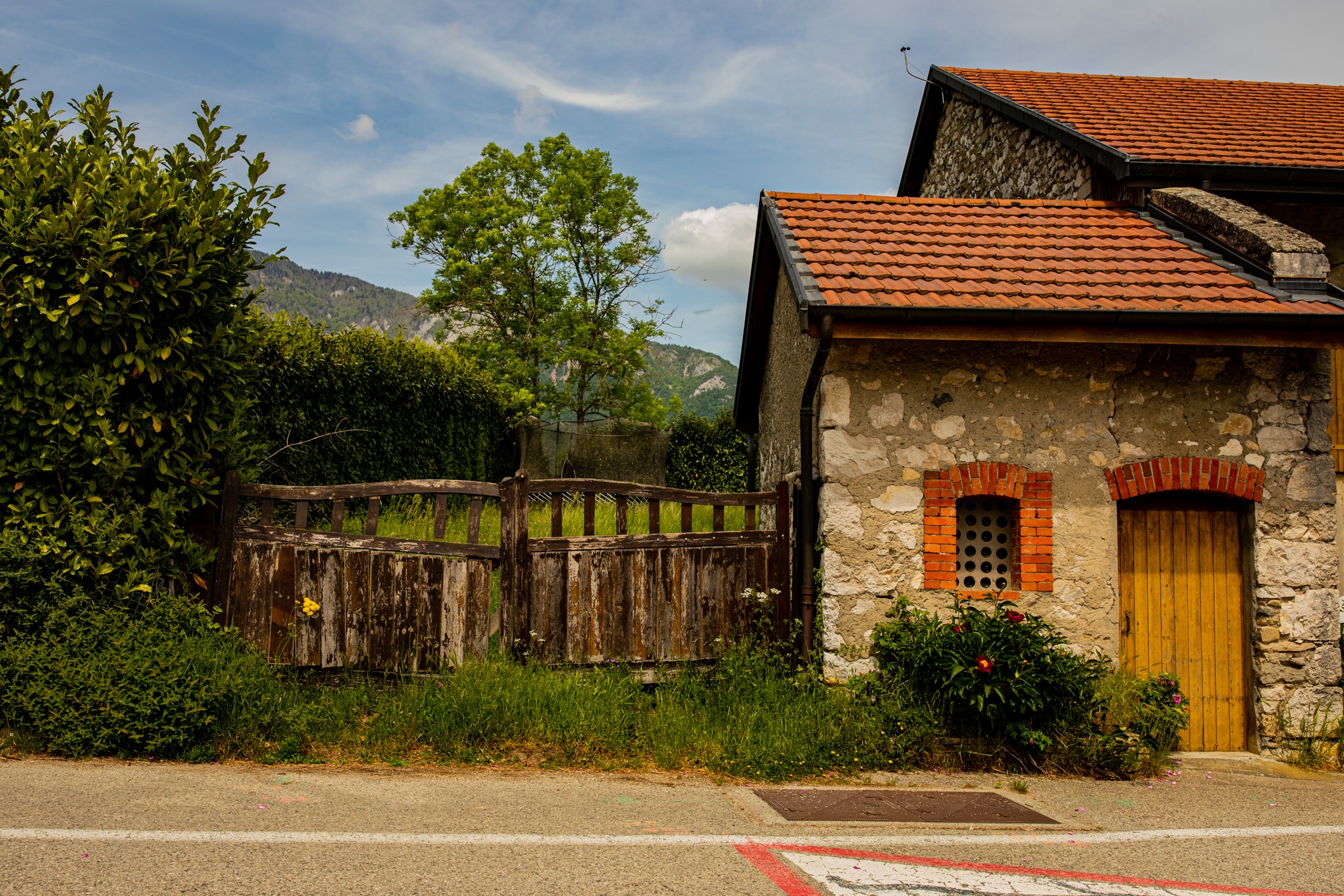 Stone building with wooden gate and mountains HD Wallpaper