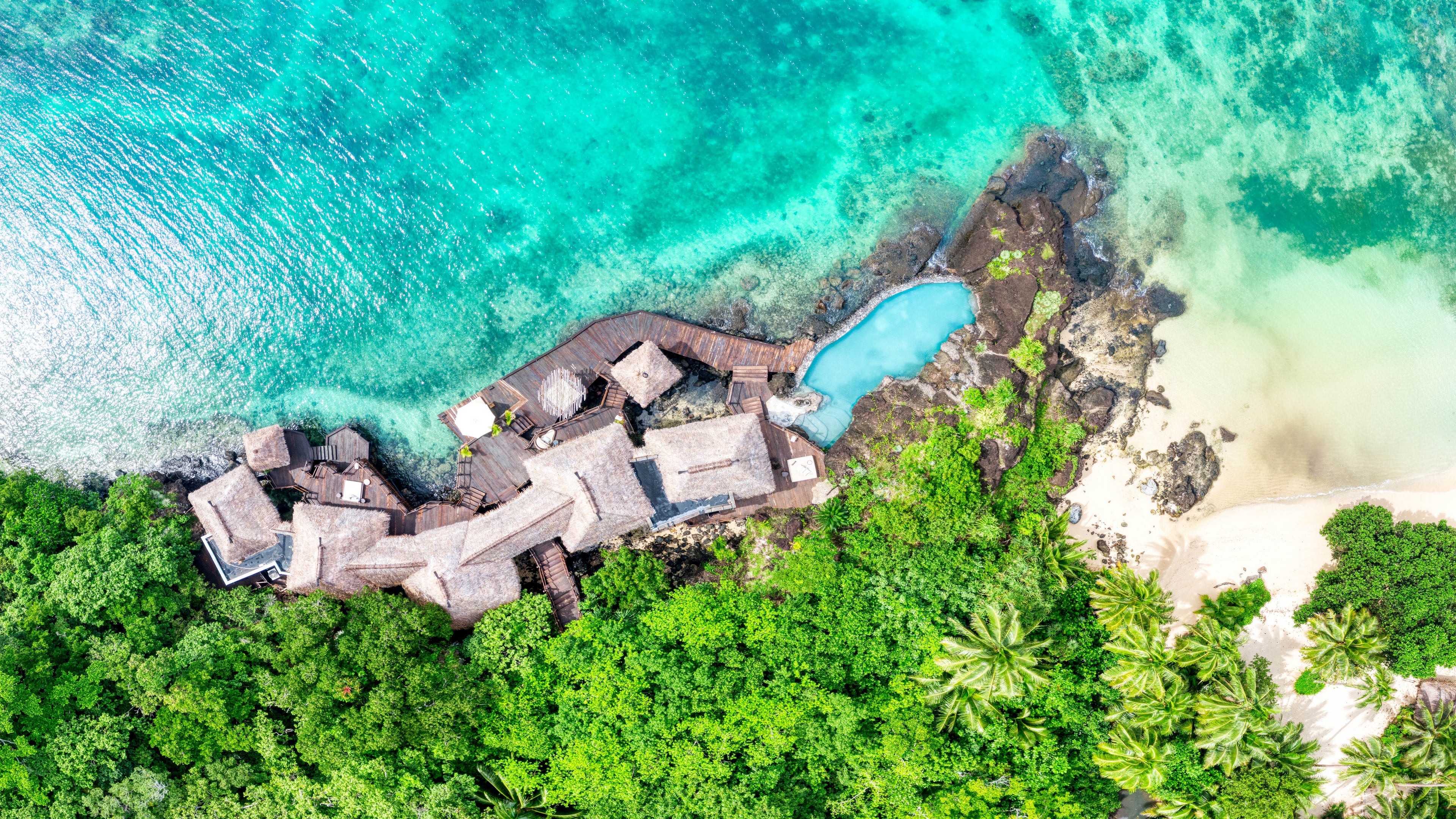 Aerial view of a resort with bungalows and a swimming pool in Fiji HD Wallpaper