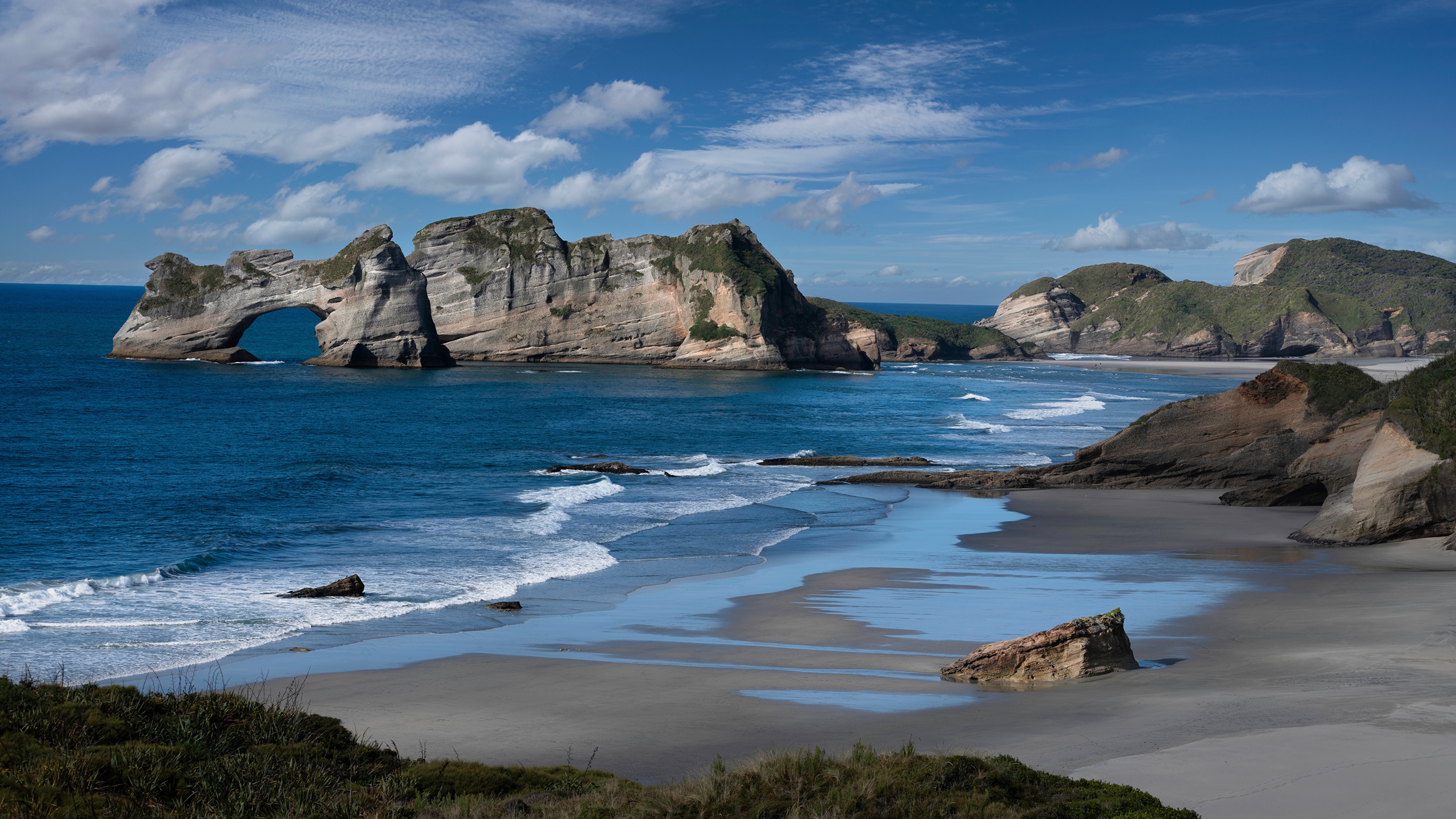 Wharariki Beach rock formation and sea under blue sky HD Wallpaper