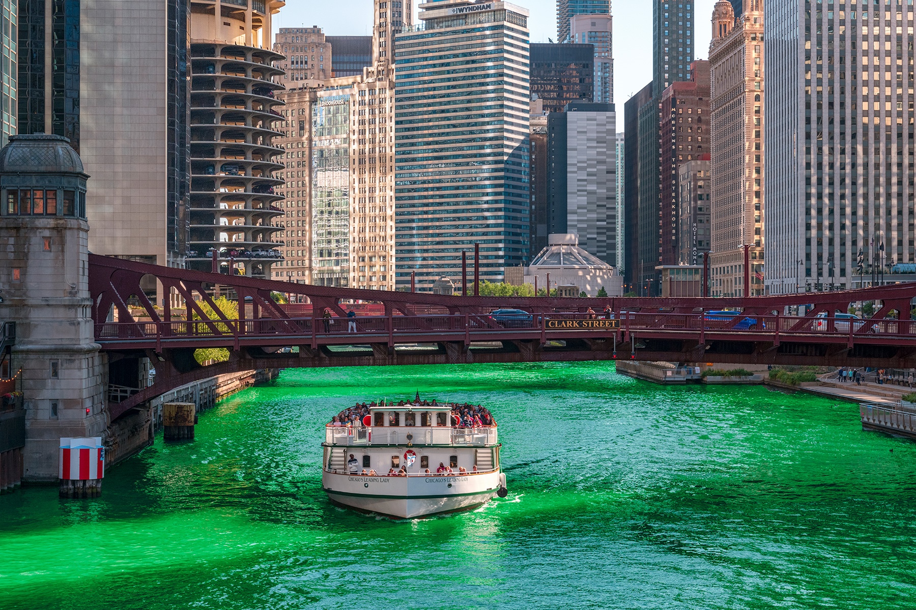 Chicago River dyed green with a tour boat passing under Clark Street Bridge HD Wallpaper