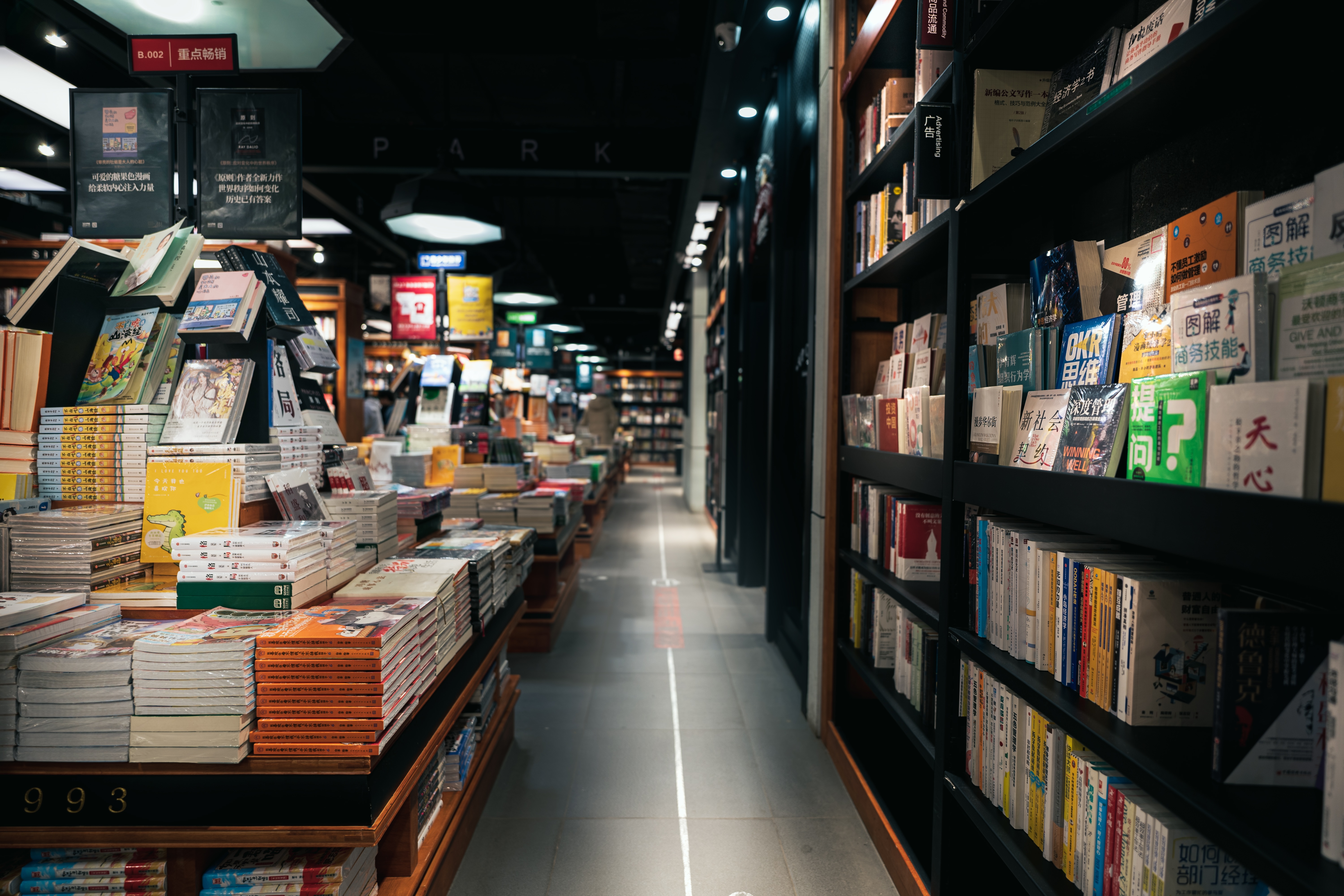 Bookstore aisle with shelves of books HD Wallpaper