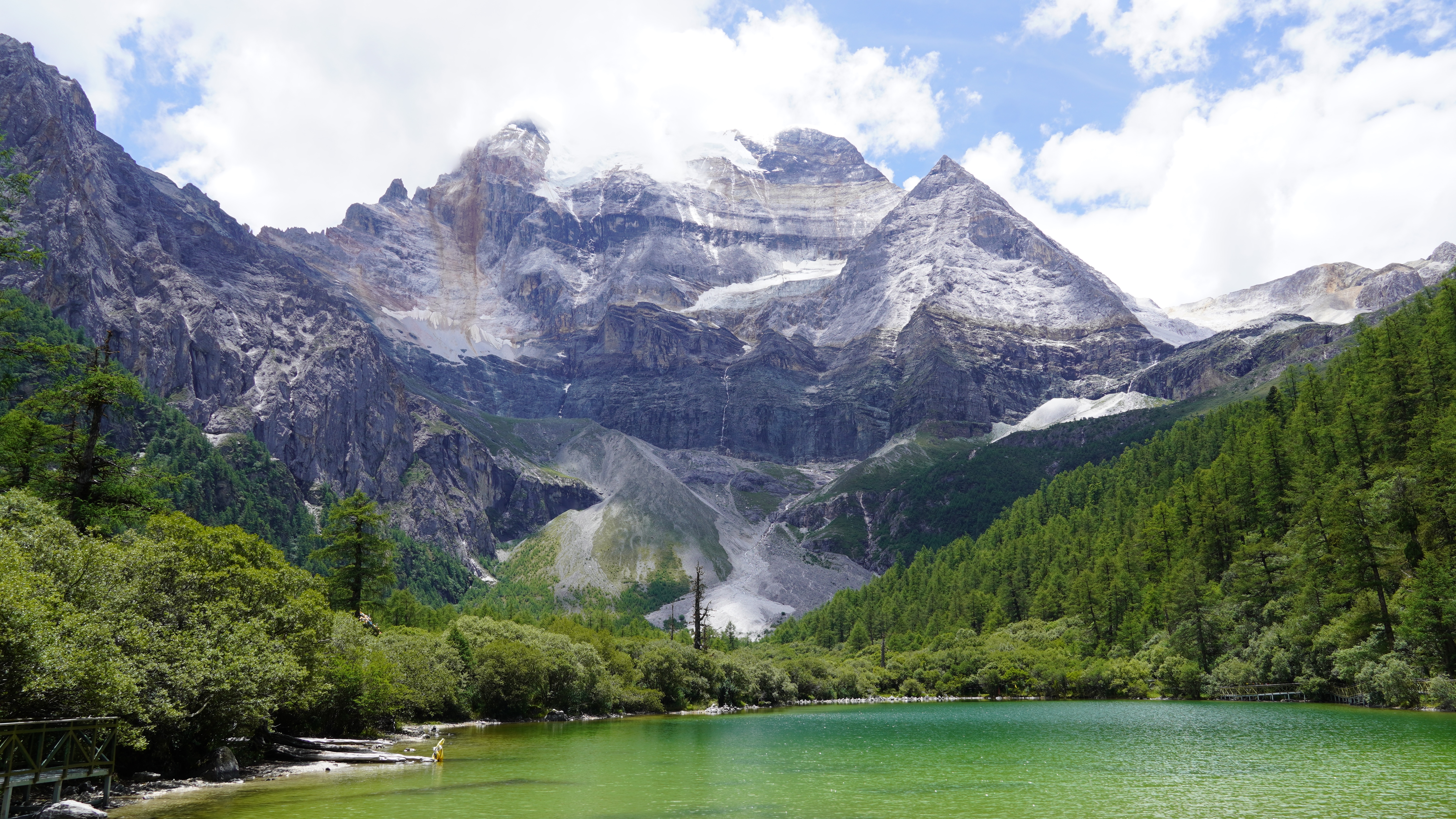 4K mountain lake with snow-capped peaks and green trees HD Wallpaper