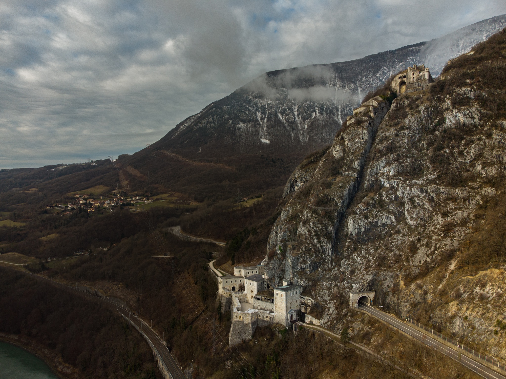 Fortifications on a rocky mountain slope with a road and tunnels HD Wallpaper