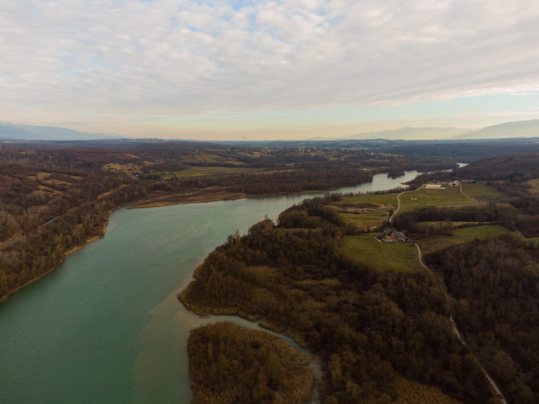 Aerial view of a river flowing through a forested landscape in France HD Wallpaper