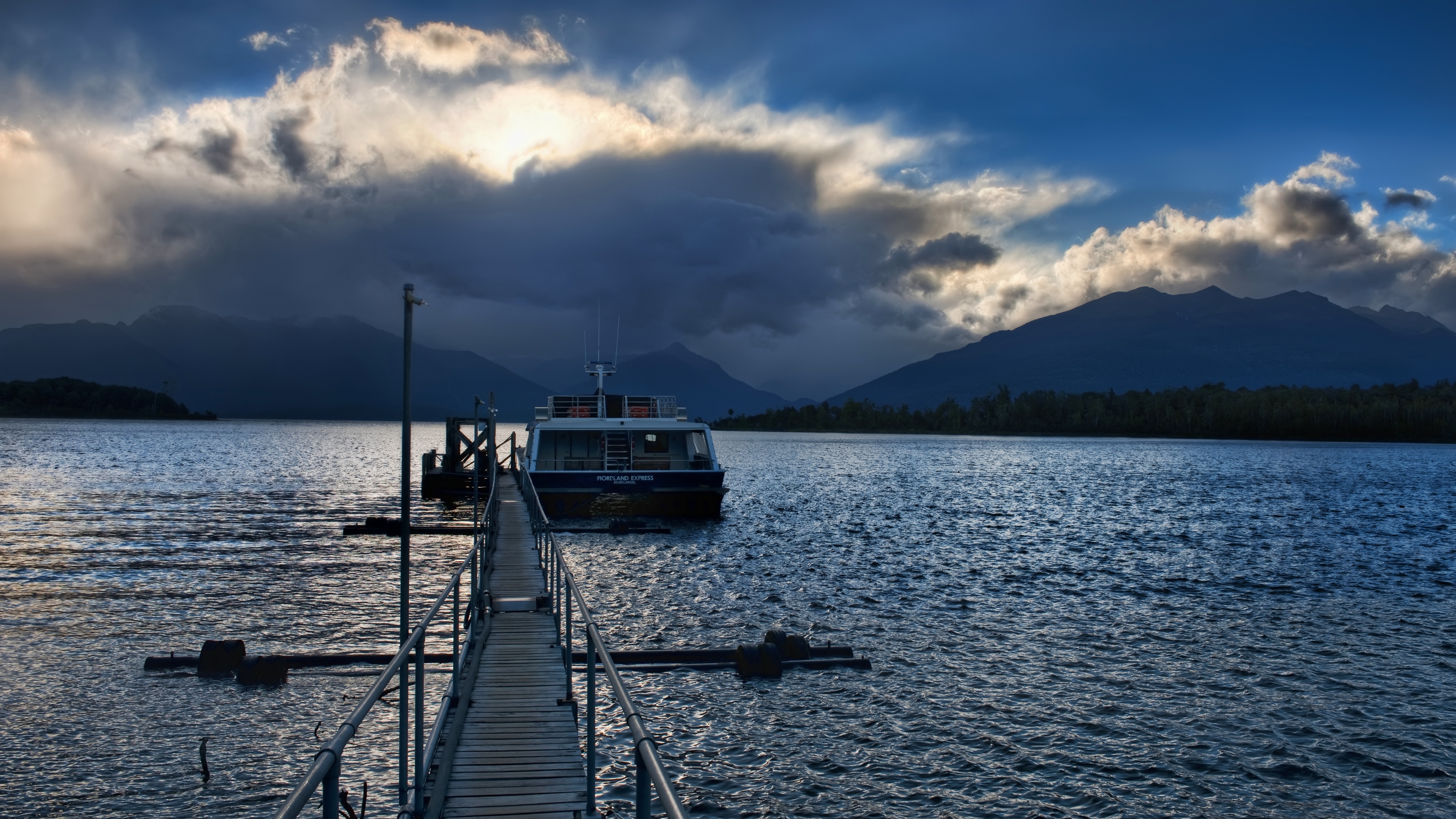 4K boat at jetty with mountains and clouds HD Wallpaper