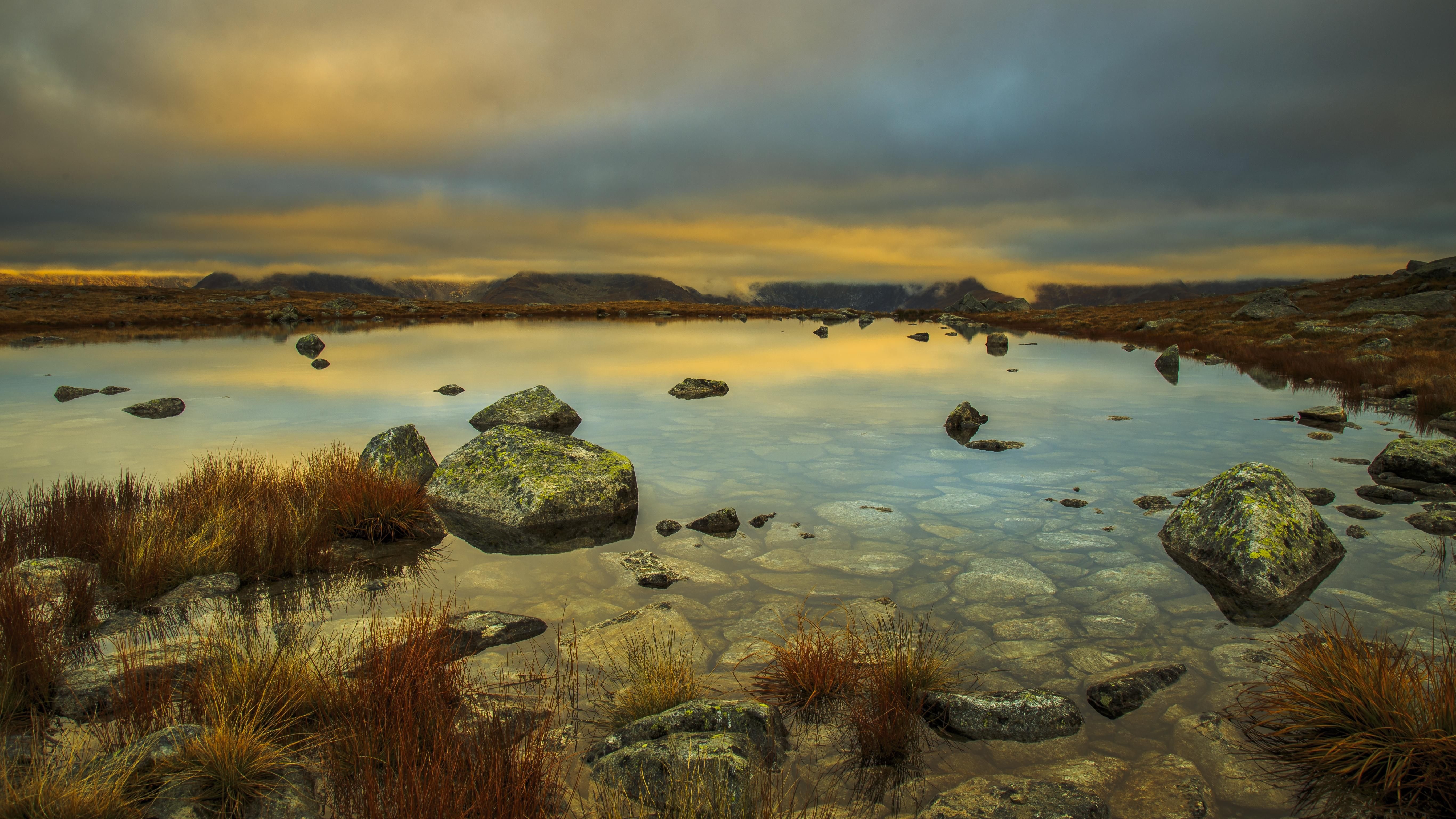 4K nature scene with pond, rocks, grass, and clouds HD Wallpaper