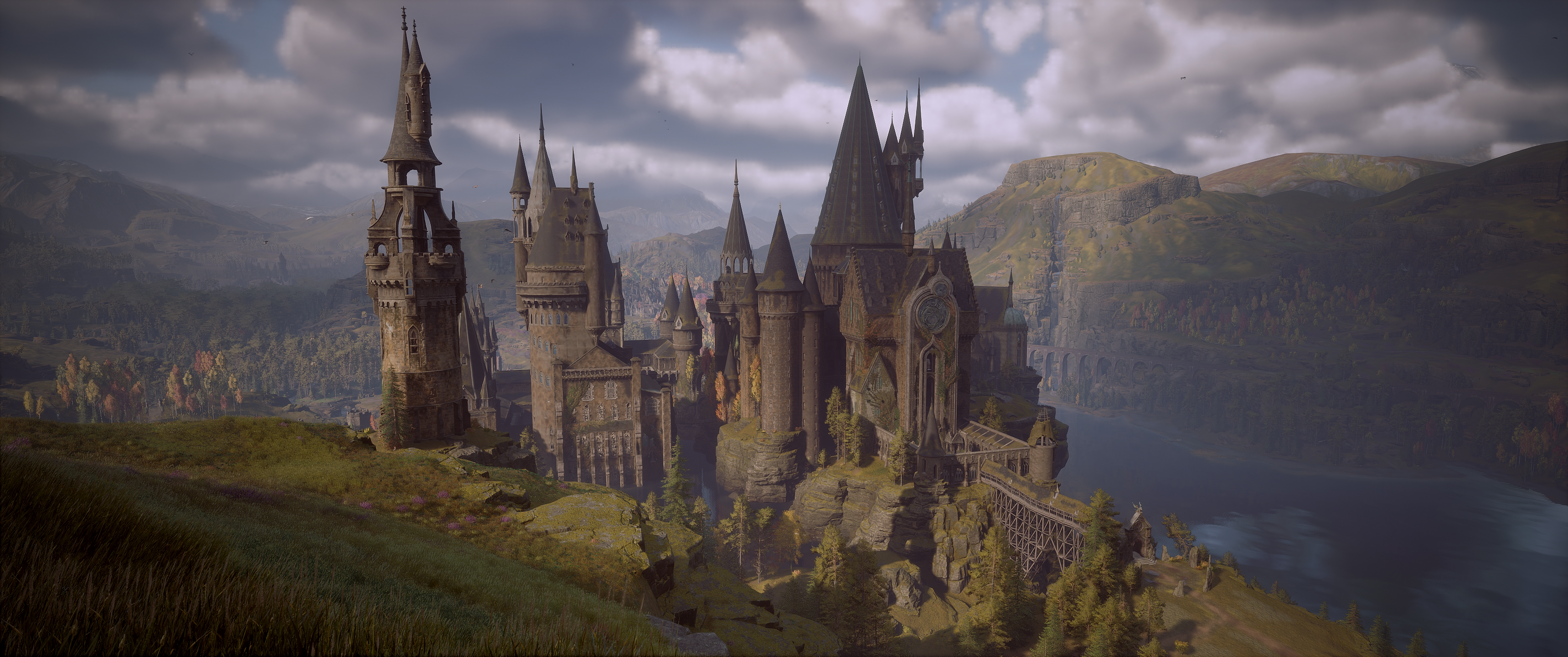 Hogwarts Legacy castle on a cliff overlooking a lake HD Wallpaper