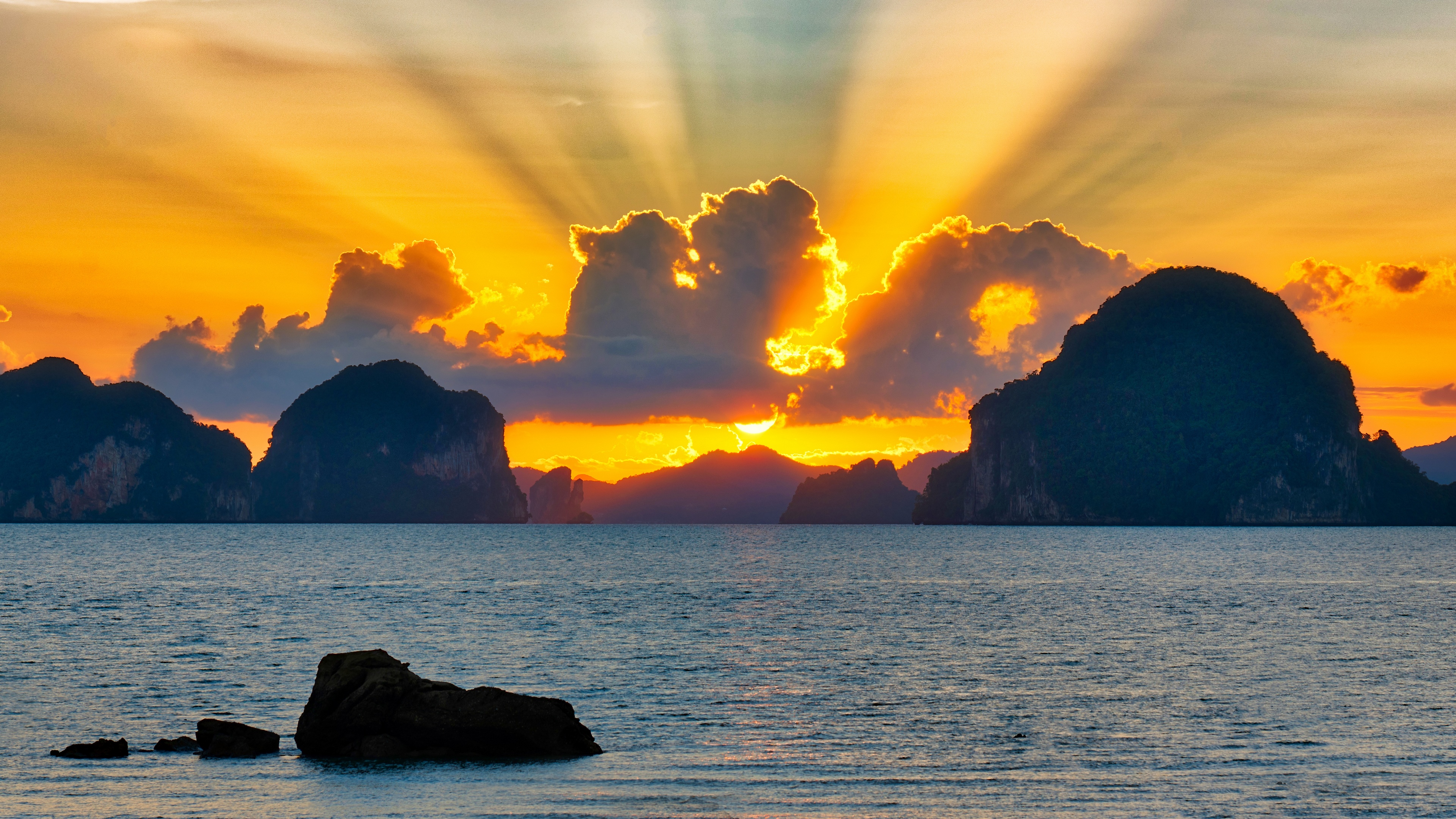 Sunset over islands with sun rays and rocks HD Wallpaper