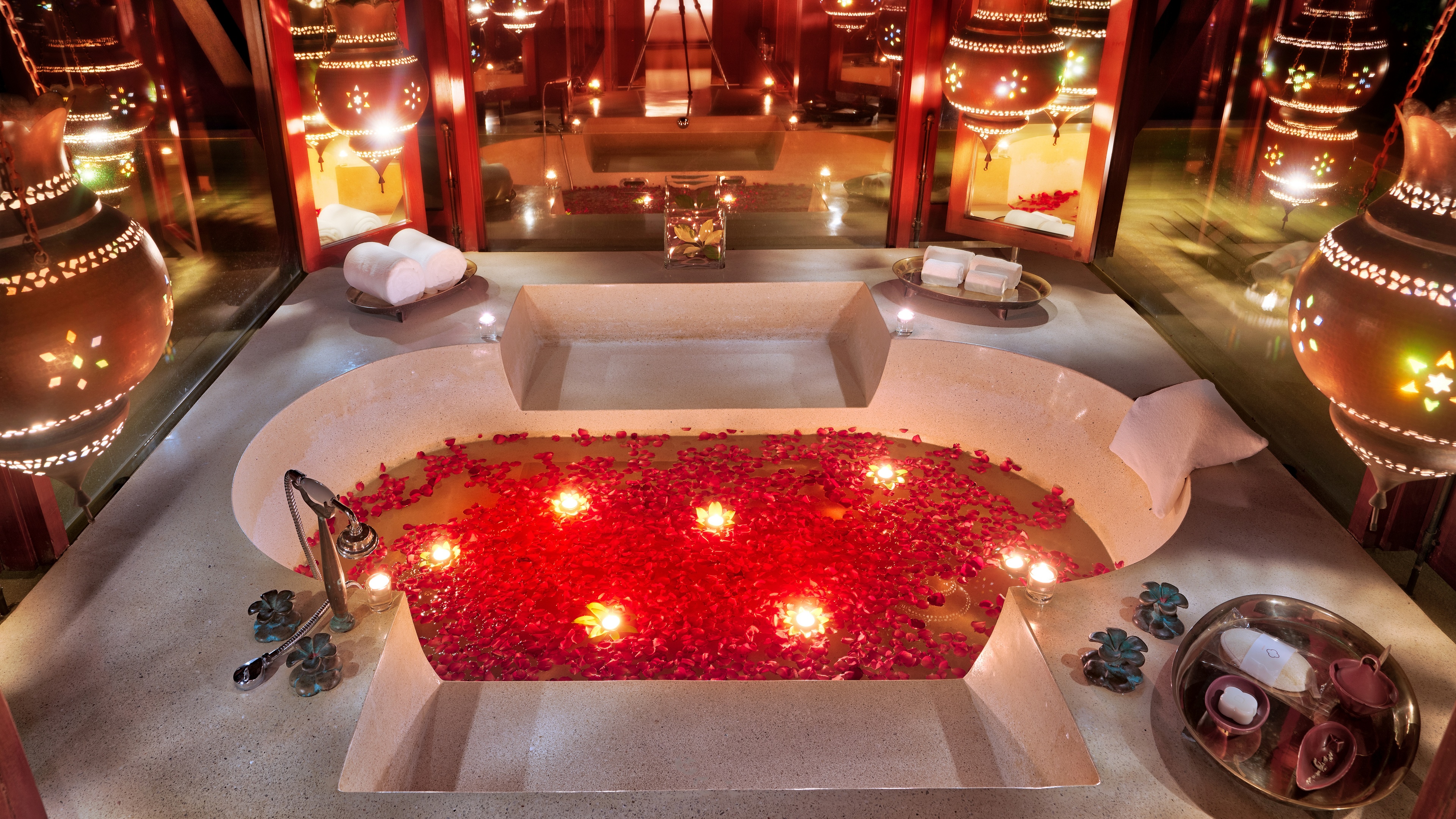 Bathtub filled with water, rose petals, and candles HD Wallpaper
