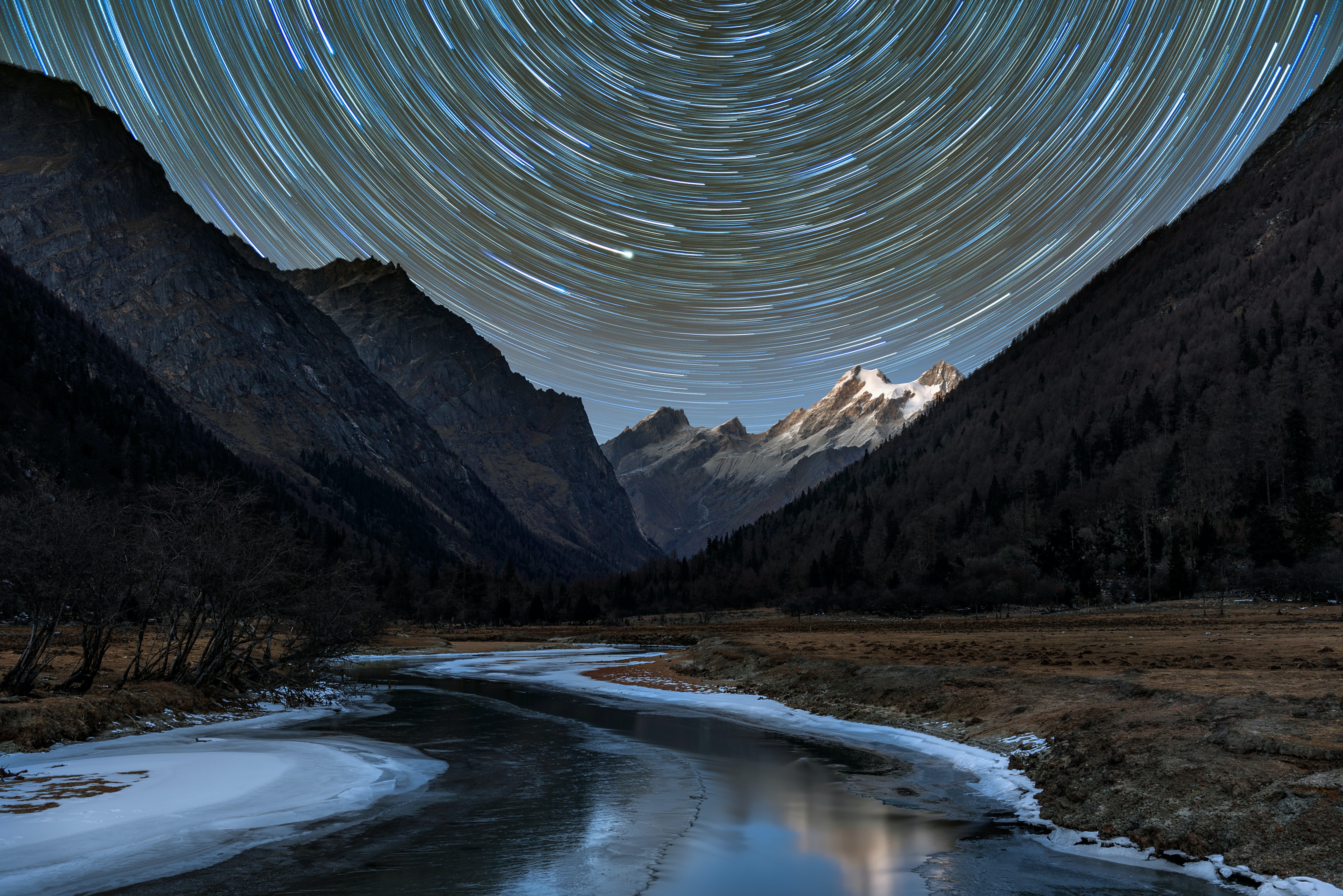 Star trails over snowy peaks and frozen river in Sichuan, China HD Wallpaper