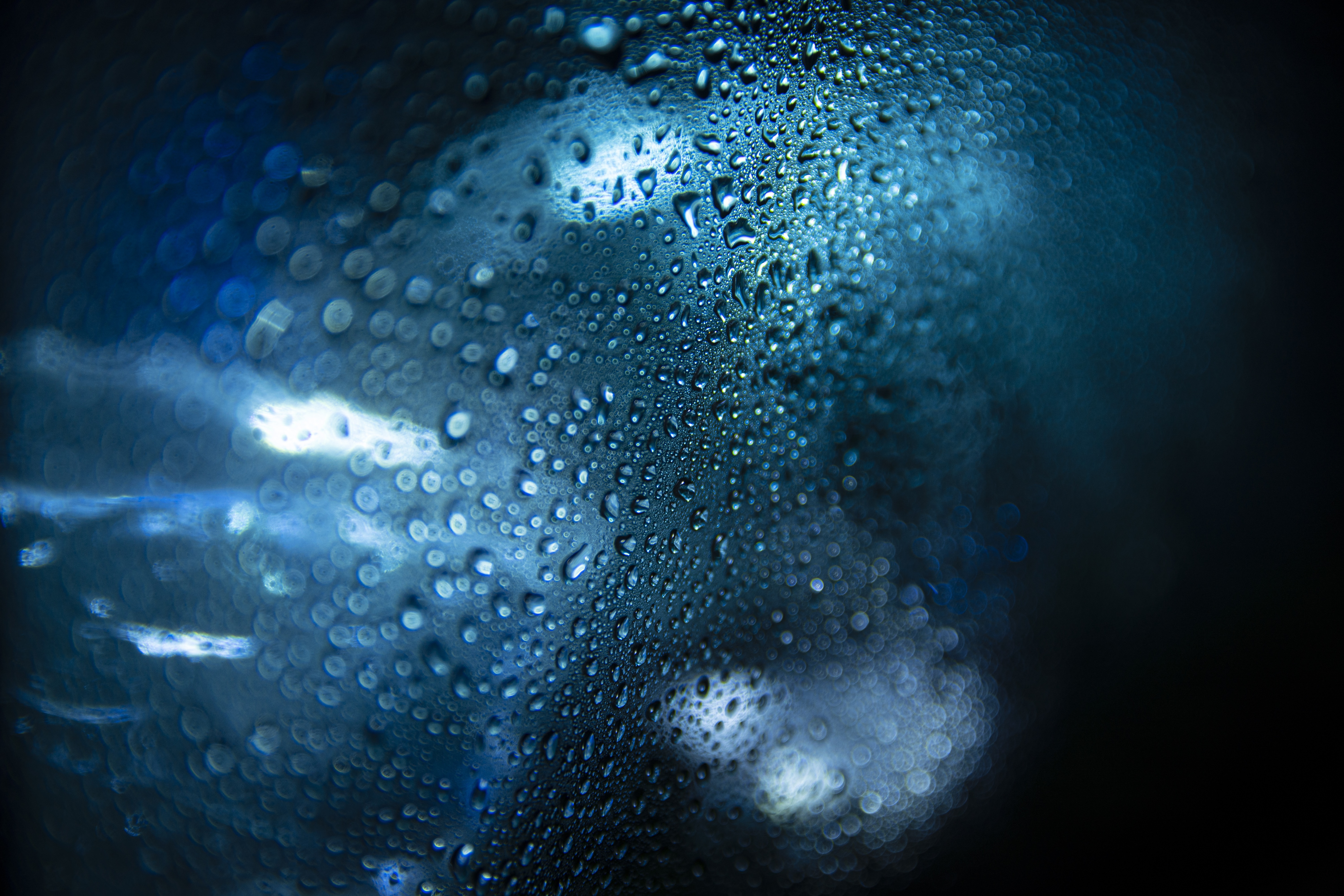 Water drops on glass with blue lights HD Wallpaper