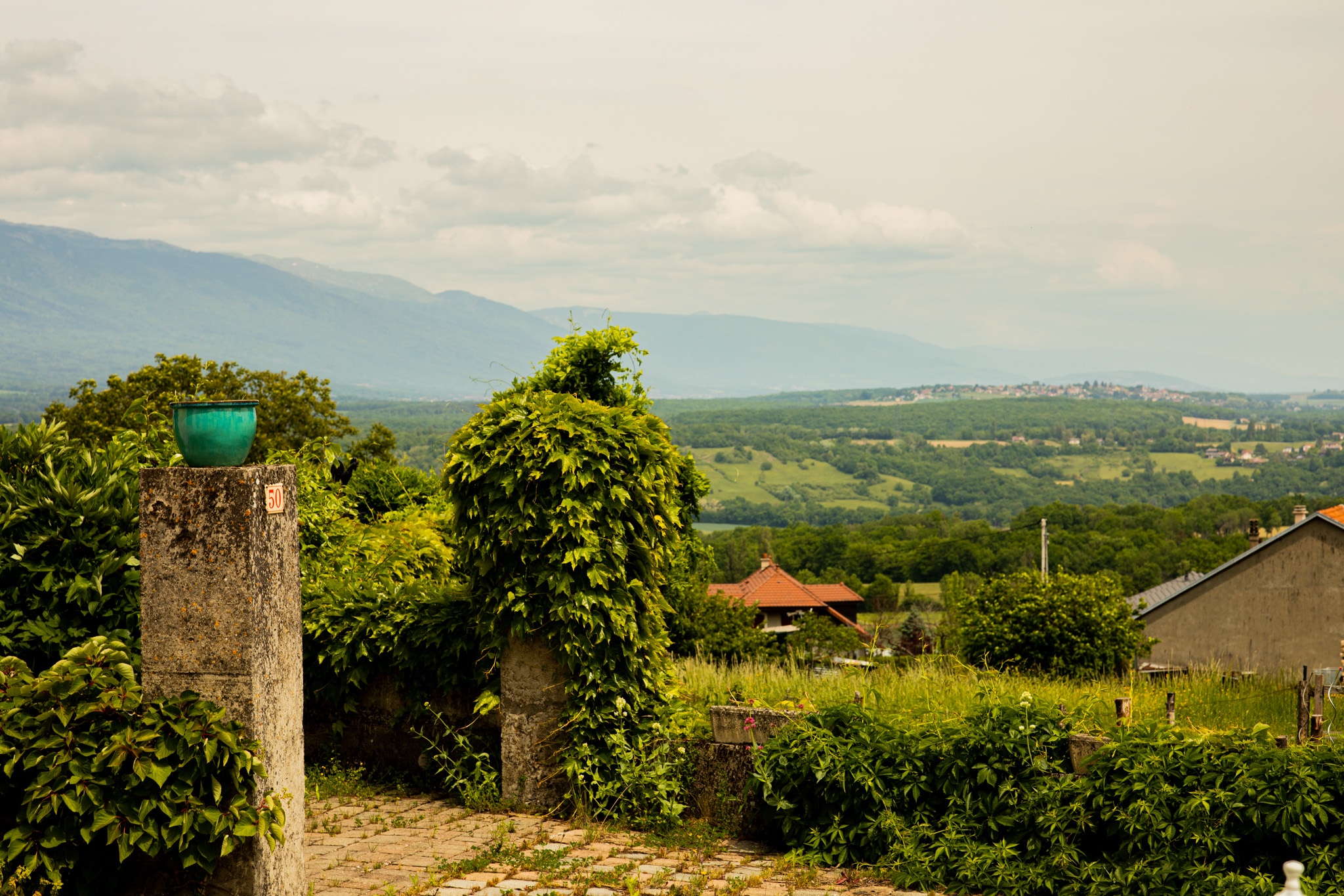 Green pot on stone pillar overlooking a valley HD Wallpaper